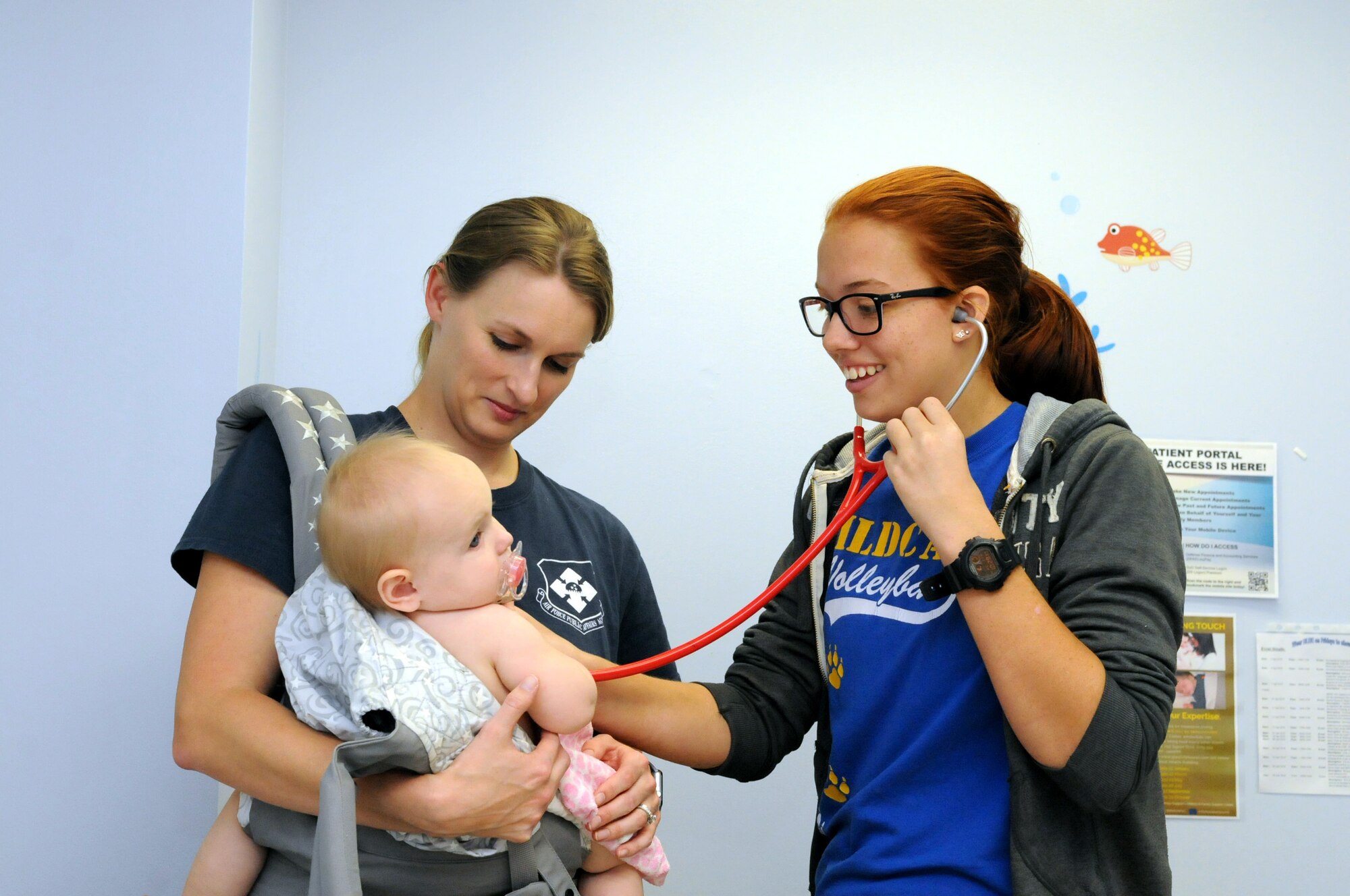 Alexis Asbury (right), a student from Radford High School, assists in a well-baby checkup at the 15th Medical Operations Squadron pediatrics clinic during Career Shadow Day at the 15th Medical Group, Joint Base Pearl Harbor-Hickam, Hawaii, March 28, 2018.