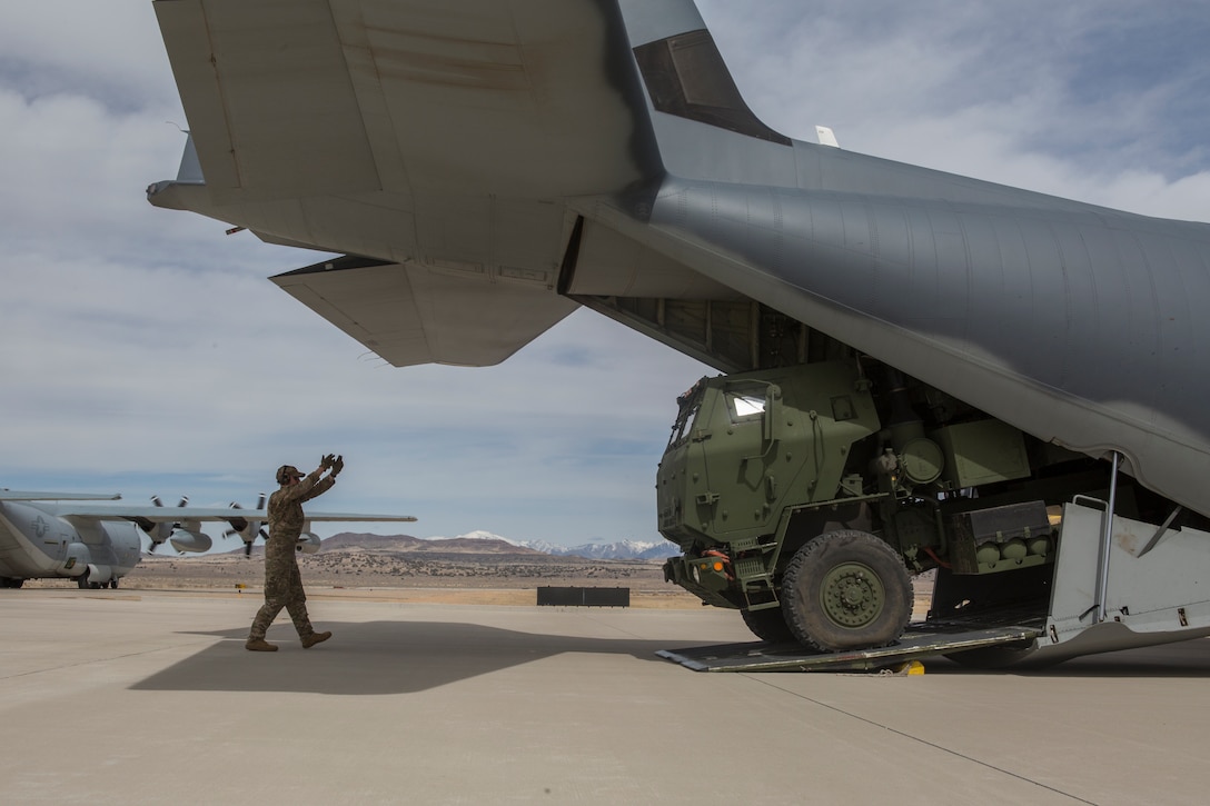 Air Force Staff Sgt. Josh Monroe, a loadmaster from 9th Special Operations Squadron, loads a Marine Corps M142 High Mobility Artillery Rocket System (HIMARS) from Kilo Battery, 2nd Battalion, 14th Marine Regiment, into an Air Force MC-130 at Dugway Proving Grounds, Utah, March 30, 2018. Marines from Kilo Battery flew from Fort Campbell, Ky., to Dugway where they offloaded and fired four HIMARS missiles, demonstrating a unique capability that will give commanders more options to deal with threats when other options are not appropriate. (Marine Corps photo by Lance Cpl. Niles Lee)