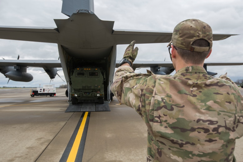 Air Force Staff Sgt. Josh Monroe, a loadmaster from 9th Special Operations Squadron, off loads a Marine Corps M142 High Mobility Artillery Rocket System (HIMARS) from an Air Force MC-130 at Fort Campbell, Ky., March 29, 2018. Marines from Kilo Battery used an Air Force MC-130 to conduct a live-fire raid at Dugway Proving Ground, Utah, flying from Fort Campbell, to Dugway. There, they offloaded and fired four HIMARS missiles, demonstrating a unique capability that will give commanders more options to deal with threats when other options are not appropriate. (Marine Corps photo by Lance Cpl. Niles Lee)