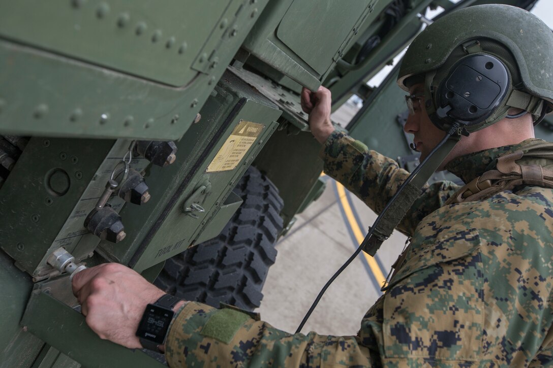 Marine Corps Cpl. Kyle Thompson, a gunner with Kilo Battery, 2nd Battalion, 14th Marine Regiment, raises the suspension on a M142 High Mobility Artillery Rocket System (HIMARS) after having been off loaded from an Air Force MC-130 at Fort Campbell, Ky., March 29, 2018. Marines from Kilo Battery flew from Fort Campbell, to Dugway Proving Grounds, Utah, where they offloaded and fired four HIMARS missiles, demonstrating a unique capability that will give commanders more options to deal with threats when other options are not appropriate. (Marine Corps photo by Lance Cpl. Niles Lee)