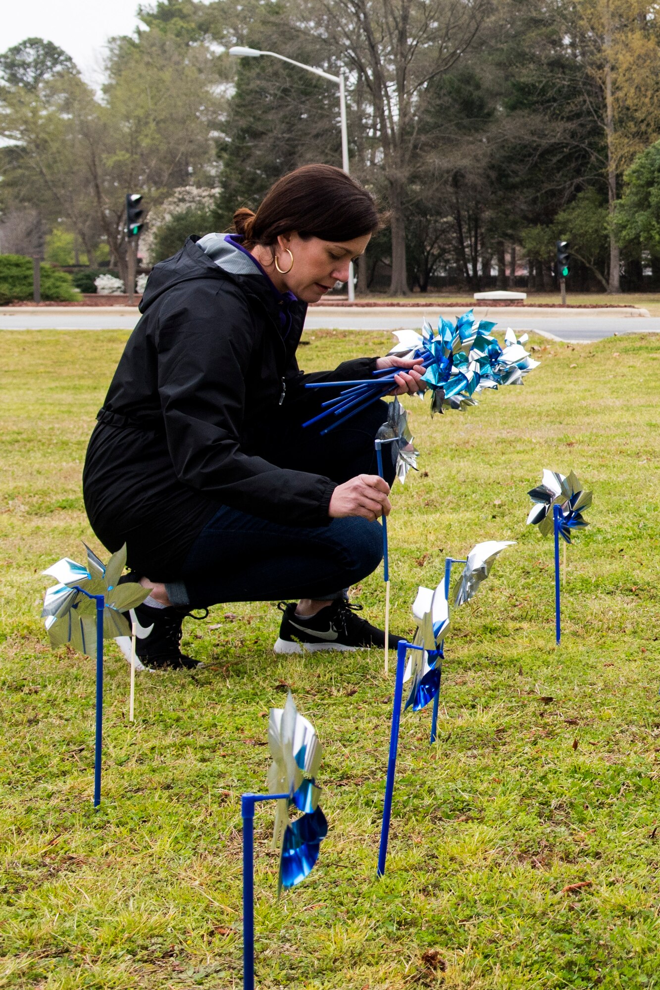 Jennifer Price, 4th Medical Operations Squadron family advocacy treatment manager, places pinwheels near the main gate to raise awareness for child abuse prevention, April 3, 2018, at Seymour Johnson Air Force Base, North Carolina.