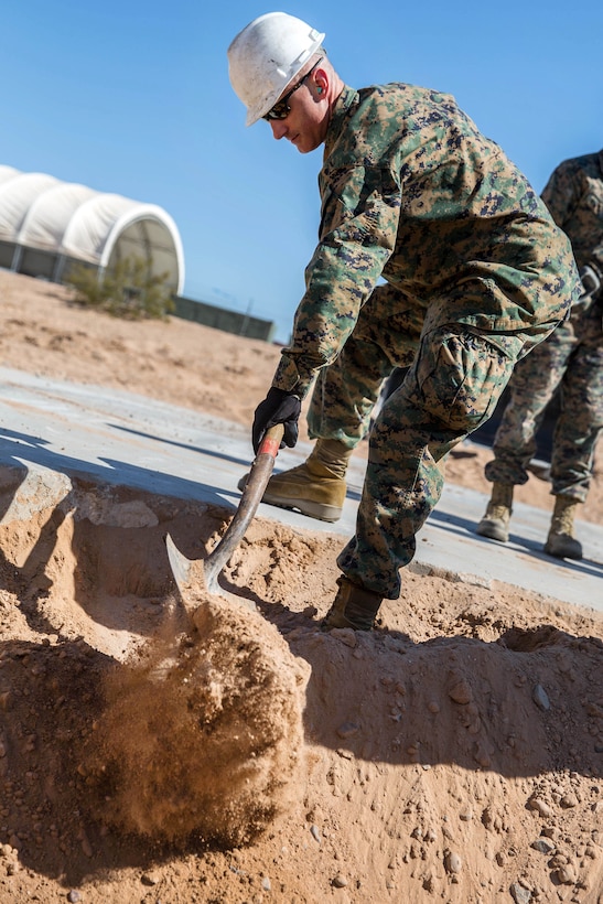 A Marine fills a crater during airfield damage repair.