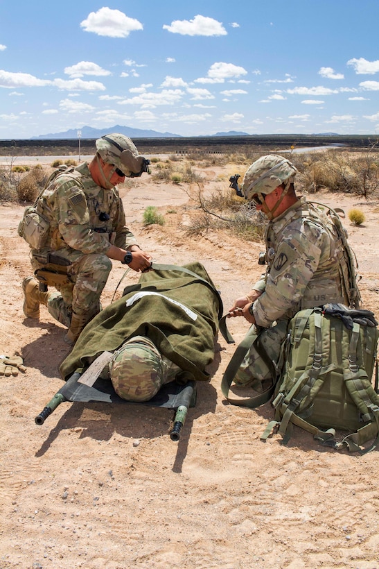 Soldiers secure a mock patient to a stretcher during a casualty evacuation exercise.