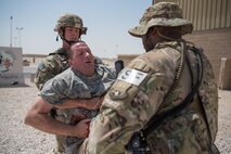 Airmen from the 379th Air Expeditionary Security Forces Squadron evacuate a simulated hostage during an attack notification response exercise at Al Udeid Air Base, Qatar, March 22, 2018. The scenario, commenced in a realistic and unanticipated manner, was designed to improve physical and procedural security as well as warning and alert notification capabilities. (U.S. Air Force photo by Staff Sgt. Joshua Horton)