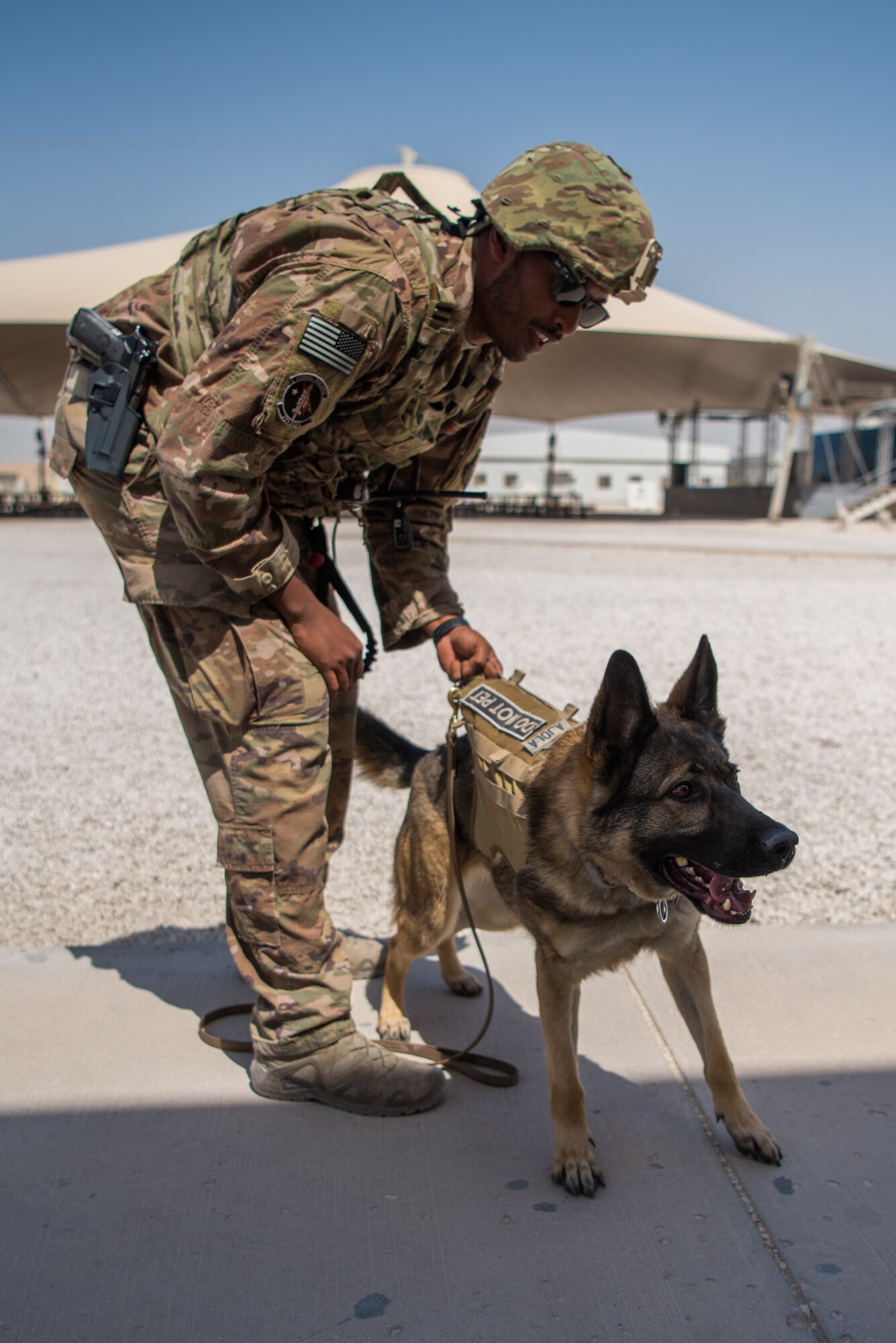 A 379th Air Expeditionary Security Forces Squadron Airman and his military working dog prepare to search a building during an attack notification response exercise at Al Udeid Air Base, Qatar, March 22, 2018. The scenario, commenced in a realistic and unanticipated manner, was designed to improve physical and procedural security as well as warning and alert notification capabilities. (U.S. Air Force photo by Staff Sgt. Joshua Horton)