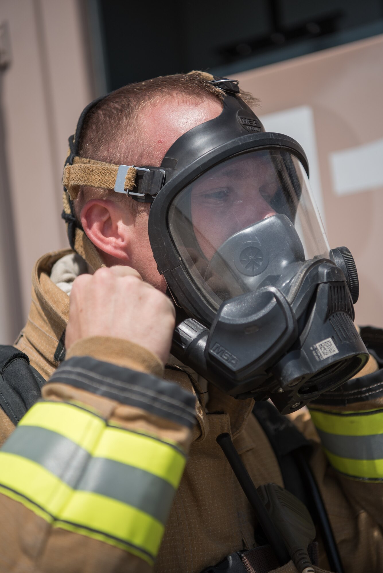 A firefighter from the 379th Expeditionary Civil Engineer Squadron prepares to extinguish a simulated fire during an attack notification response exercise at Al Udeid Air Base, Qatar, March 22, 2018. The scenario, commenced in a realistic and unanticipated manner, was designed to improve physical and procedural security as well as warning and alert notification capabilities. (U.S. Air Force photo by Staff Sgt. Joshua Horton)