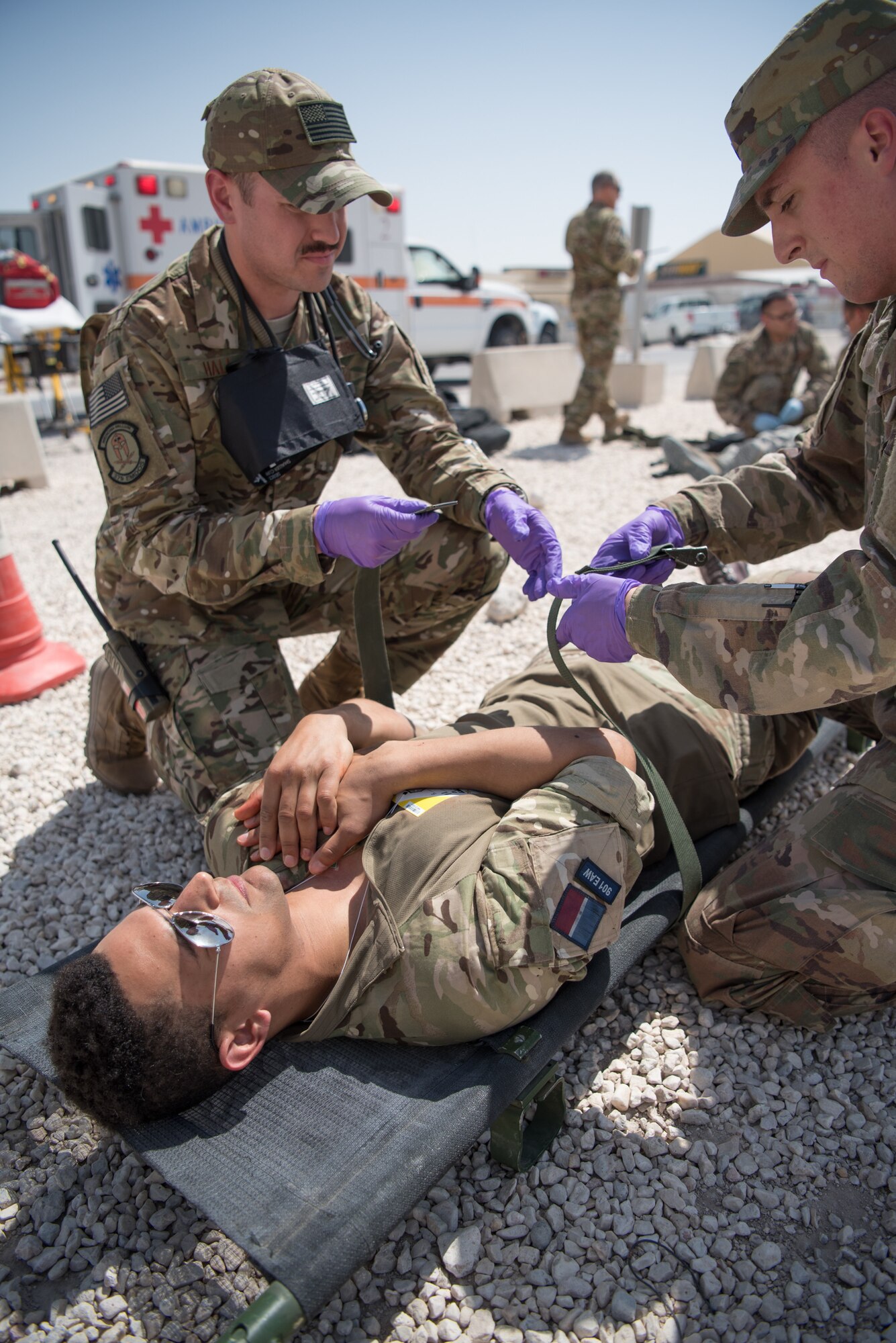 Airmen from the 379th Expeditionary Medical Operations Squadron provide medical evacuation to a simulated hostage during an attack notification response exercise at Al Udeid Air Base, Qatar, March 22, 2018. The scenario, commenced in a realistic and unanticipated manner, was designed to improve physical and procedural security as well as warning and alert notification capabilities. (U.S. Air Force photo by Staff Sgt. Joshua Horton)