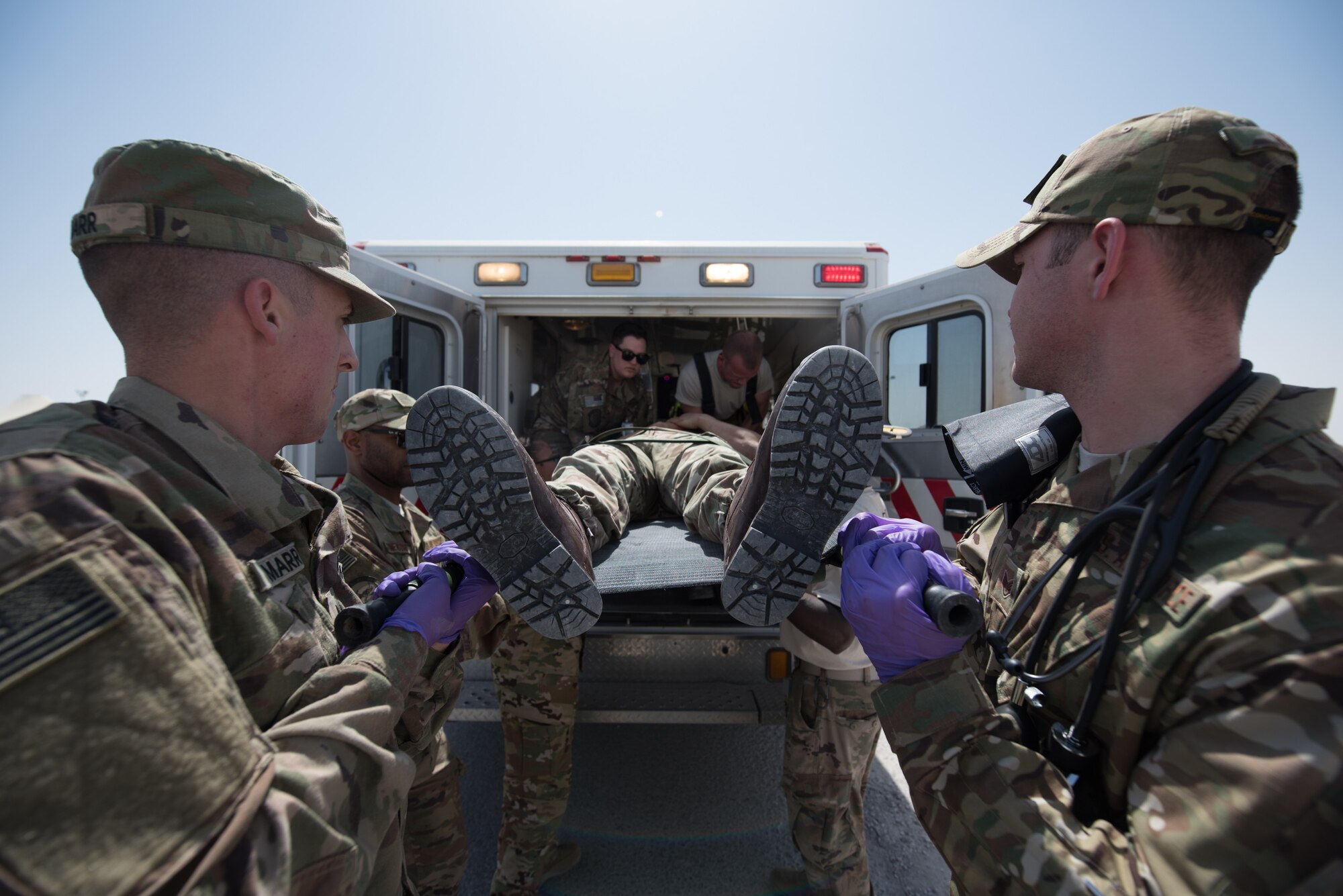 Airmen from the 379th Expeditionary Medical Operations Squadron provide medical evacuation to a simulated hostage during an attack notification response exercise at Al Udeid Air Base, Qatar, March 22, 2018. The scenario, commenced in a realistic and unanticipated manner, was designed to improve physical and procedural security as well as warning and alert notification capabilities. (U.S. Air Force photo by Staff Sgt. Joshua Horton)