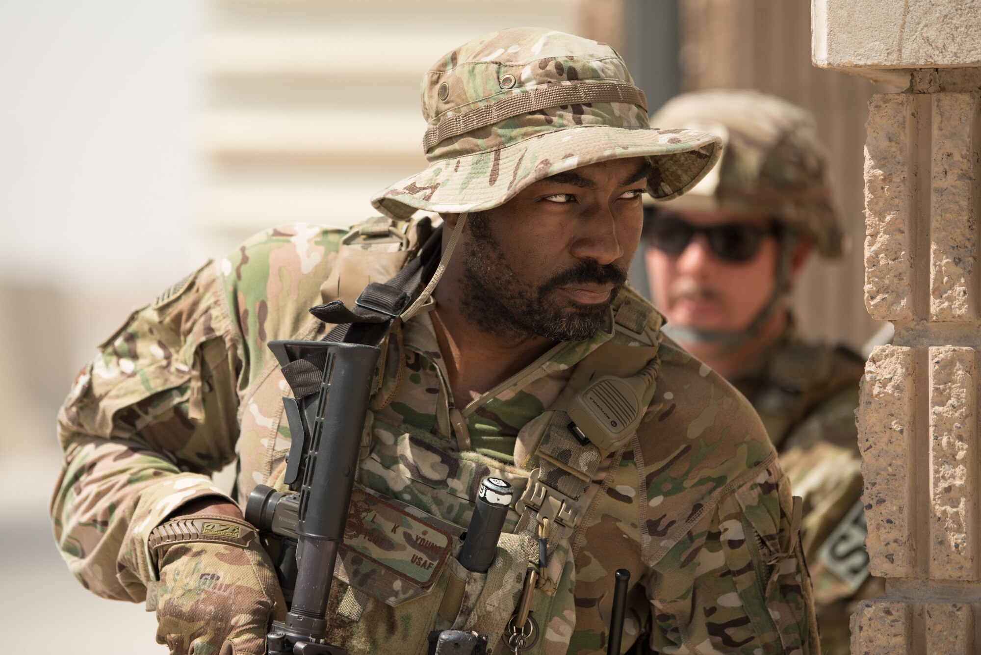 Airmen from the 379th Air Expeditionary Security Forces Squadron prepare to infiltrate a building during an attack notification response exercise at Al Udeid Air Base, Qatar, March 22, 2018. The scenario, commenced in a realistic and unanticipated manner, was designed to improve physical and procedural security as well as warning and alert notification capabilities. (U.S. Air Force photo by Staff Sgt. Joshua Horton)