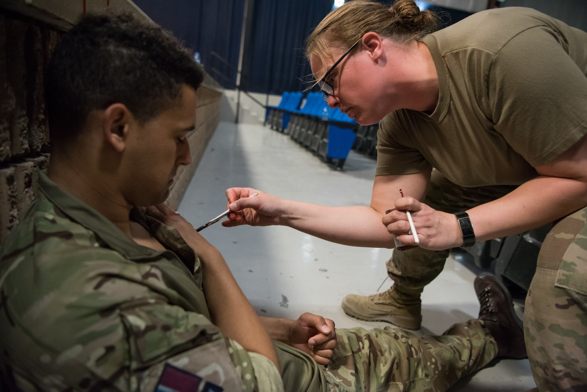 A moulage is applied to a simulated hostage during an attack notification response exercise at Al Udeid Air Base, Qatar, March 22, 2018. The scenario, commenced in a realistic and unanticipated manner, was designed to improve physical and procedural security as well as warning and alert notification capabilities. (U.S. Air Force photo by Staff Sgt. Joshua Horton)