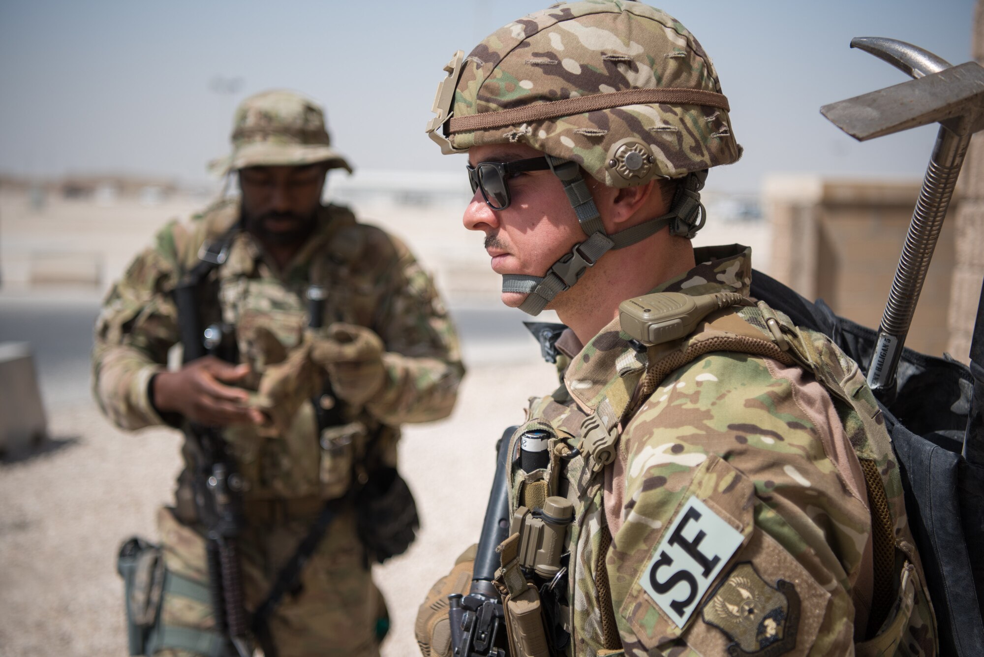 Airmen from the 379th Air Expeditionary Security Forces Squadron prepare to infiltrate a building during an attack notification response exercise at Al Udeid Air Base, Qatar, March 22, 2018. The scenario, commenced in a realistic and unanticipated manner, was designed to improve physical and procedural security as well as warning and alert notification capabilities. (U.S. Air Force photo by Staff Sgt. Joshua Horton)