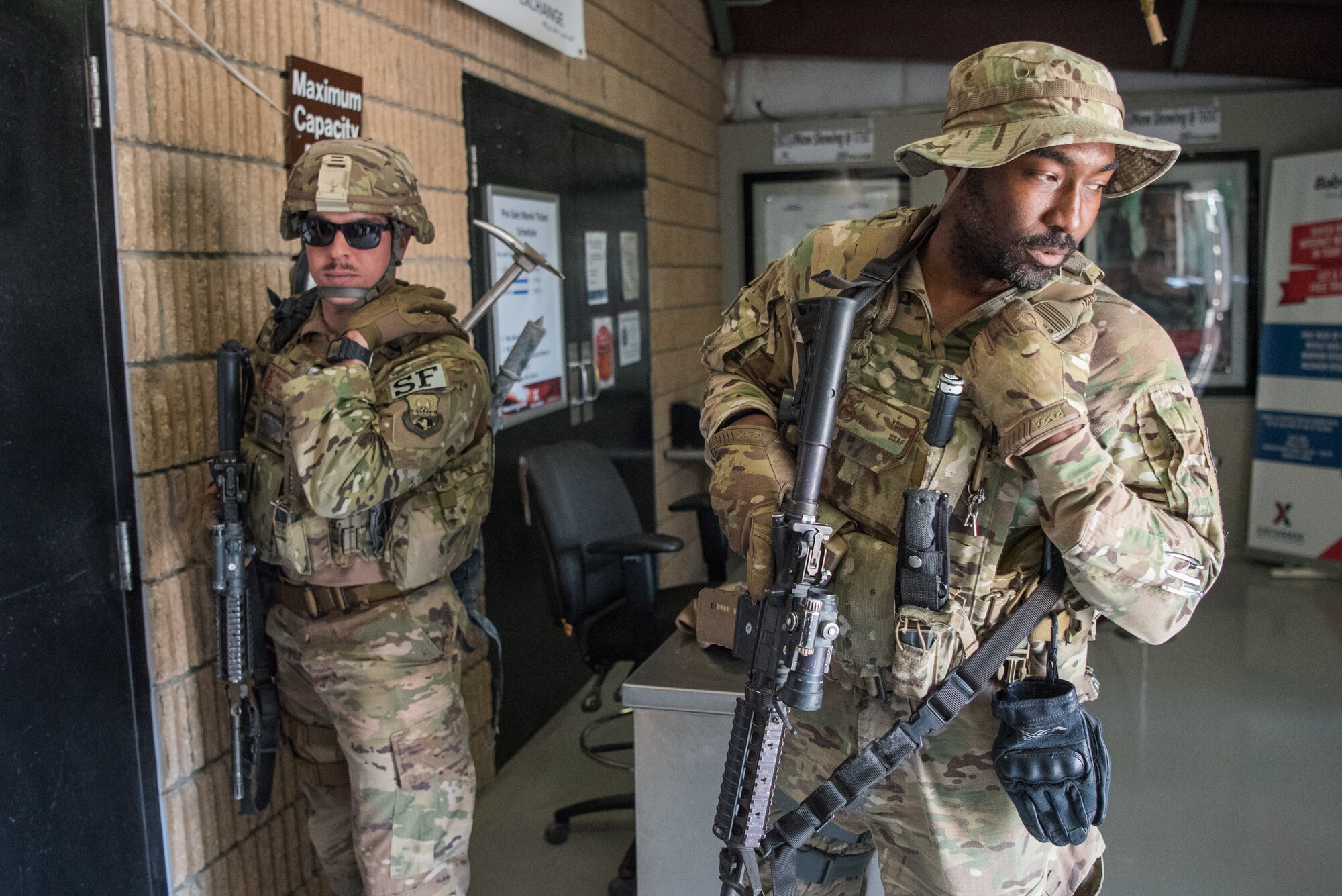 Airmen from the 379th Air Expeditionary Security Forces Squadron prepare to infiltrate a building during an attack notification response exercise at Al Udeid Air Base, Qatar, March 22, 2018. The scenario, commenced in a realistic and unanticipated manner, was designed to improve physical and procedural security as well as warning and alert notification capabilities. (U.S. Air Force photo by Staff Sgt. Joshua Horton)
