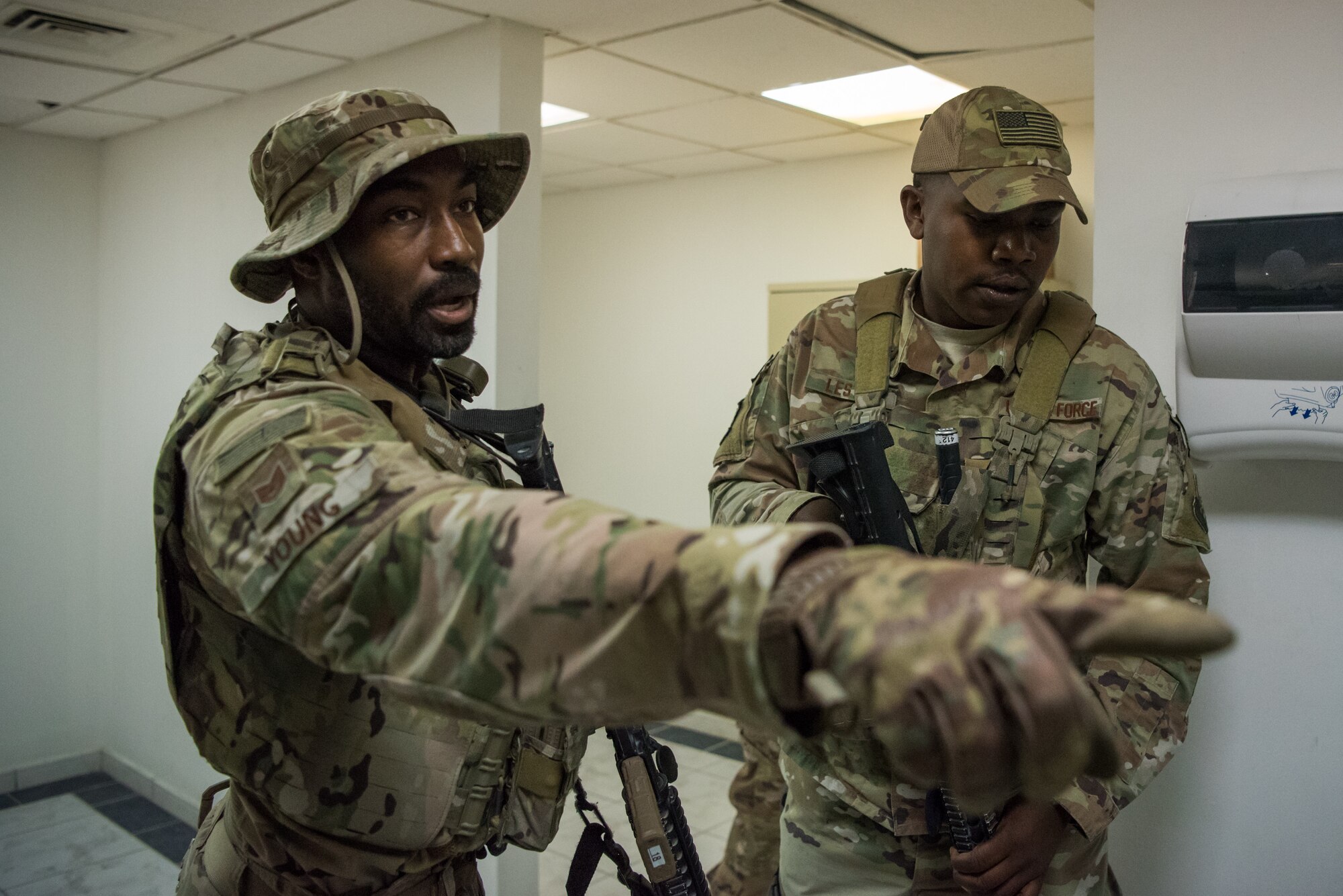 Airmen from the 379th Air Expeditionary Security Forces Squadron infiltrate a building during an attack notification response exercise at Al Udeid Air Base, Qatar, March 22, 2018. The scenario, commenced in a realistic and unanticipated manner, was designed to improve physical and procedural security as well as warning and alert notification capabilities. (U.S. Air Force photo by Staff Sgt. Joshua Horton)