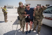 Airmen from the 379th Air Expeditionary Security Forces Squadron evacuate a simulated hostage during an attack notification response exercise at Al Udeid Air Base, Qatar, March 22, 2018. The scenario, commenced in a realistic and unanticipated manner, was designed to improve physical and procedural security as well as warning and alert notification capabilities. (U.S. Air Force photo by Staff Sgt. Joshua Horton)