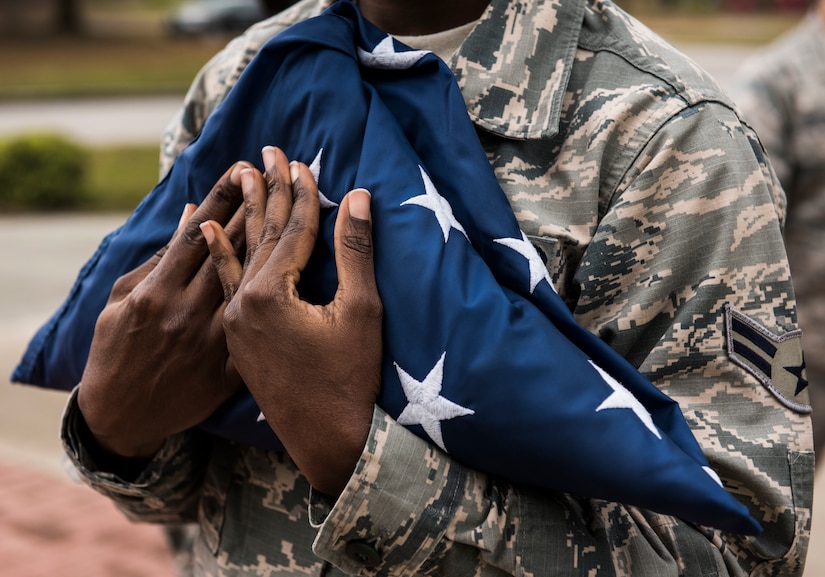 Airman 1st Class Julie-Ann Banton, 628th Air Base Wing paralegal specialist, carries the U.S. flag during a retreat ceremony March 30, 2018, at Joint Base Charleston, S.C.