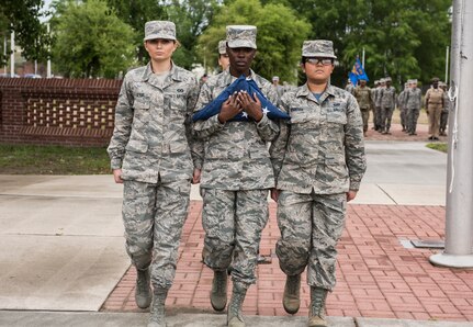 Airman Cierra Benak, left, 16th Airlift Squadron aviation resource manager technician, marches with Airman 1st Class Beatrix Bainter, right, 628th Force Support Squadron management technician, as Airman 1st Class Julie-Ann Banton, center, 628th Air Base Wing paralegal specialist, carries the U.S. flag during a retreat ceremony March 30, 2018, at Joint Base Charleston, S.C.