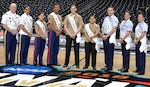 The 2018 Joint Base San Antonio Ambassadors pose at midcourt before the NCAA Division I men's basketball championship game at the Alamodome Monday, April 2, 2018. From left ot right are: Army Sgt. 1st Class Nicholas J. Warner; Army Sgt. 1st Class Latrise N. Flanigan, Marine Cpl. Emanuela Shehu, Marine Sgt. Jonaton T. McFadden Jr., Navy Petty Officer 1st Class Shannon Chatterto, Navy Petty Officer 2nd Class Diana Mendoza De Saenz, Air Force Tech. Sgt. Christofer Mercad, Air Force Tech. Sgt. Melissa M. Bennett and Coast Guard Petty Officer 1st Class Victoria Toth.