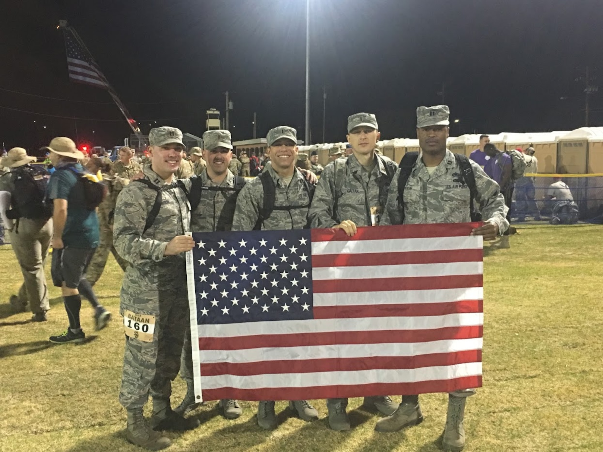 A team from Altus Air Force Base, Okla. holds up the American Flag before participating in the 29th annual Bataan Memorial Death March, March 25, 2018, at White Sands, N.M.