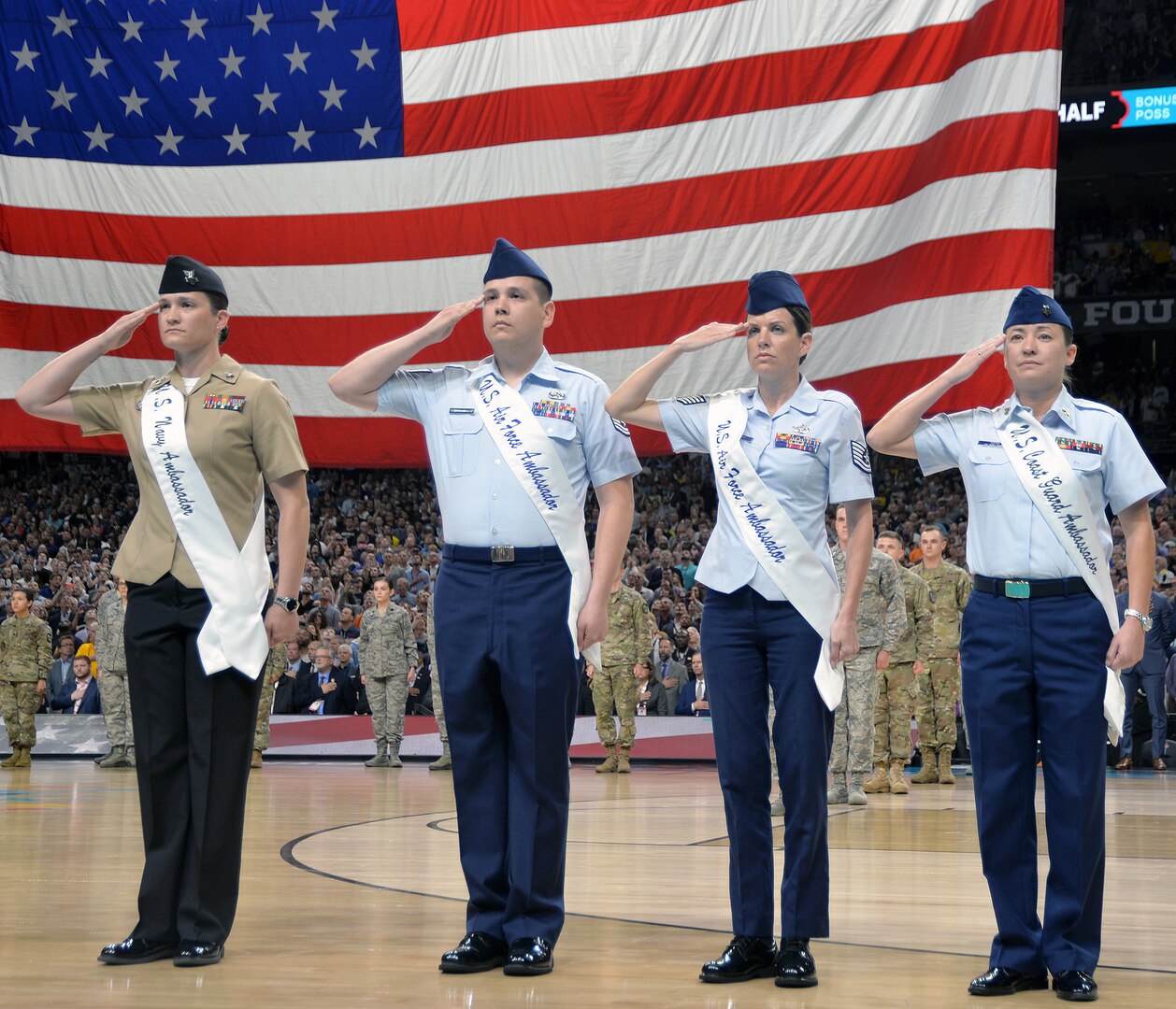 Members of the 2018 Joint Base San Antonio Ambassadors salute during the National Anthem as part of the pregame ceremonies at the NCAA Division I men's basketball championship game at the Alamodome Monday, April 2, 2018. From left are Petty Officer 1st Class Shannon Chatterton, Tech. Sgt. Christofer Mercado, Tech. Sgt. Melissa Bennett and Petty Officer 1st Class Victoria Toth.
