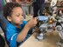 Three-year-old Sam Slentz-Bobo works on a Lego robot during the ribbon cutting ceremony for the new Center of Innovation at Kirtland Youth Programs on Thursday, March 29. The center was constructed using a $45,000 grant from Raytheon and the Boys and Girls Clubs of America.