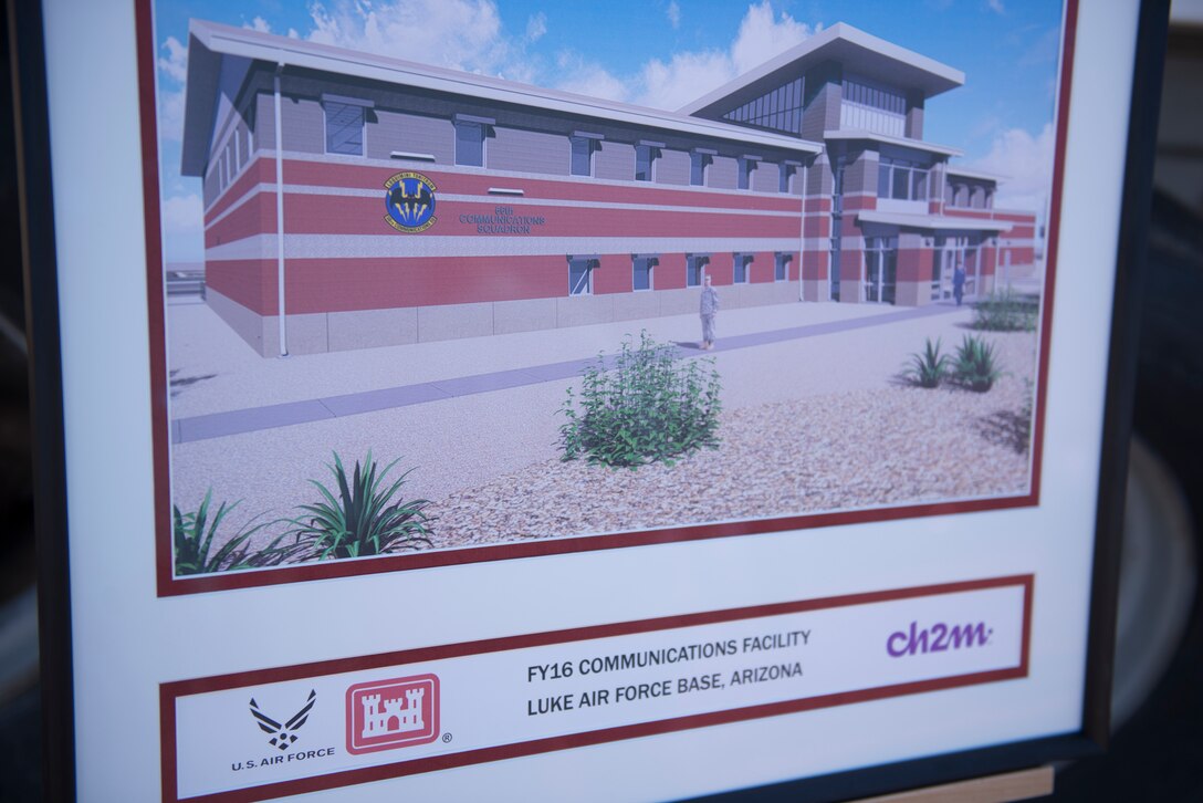A concept image of the 56th Communications Squadron’s future operations building sits in front of the site of its groundbreaking ceremony at Luke Air Force Base, Ariz., March 28, 2018. The building is being constructed in a joint effort between the 56th CS, the 56th Civil Engineer Squadron, the Army Corps of Engineers, and private contractors. (U.S. Air Force photo by Senior Airman Ridge Shan)