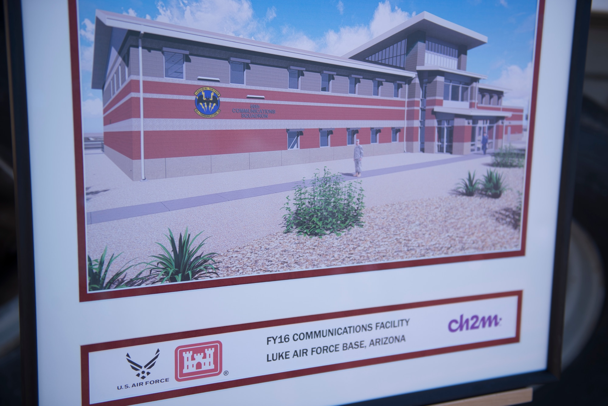 A concept image of the 56th Communications Squadron’s future operations building sits in front of the site of its groundbreaking ceremony at Luke Air Force Base, Ariz., March 28, 2018. The building is being constructed in a joint effort between the 56th CS, the 56th Civil Engineer Squadron, the Army Corps of Engineers, and private contractors. (U.S. Air Force photo by Senior Airman Ridge Shan)