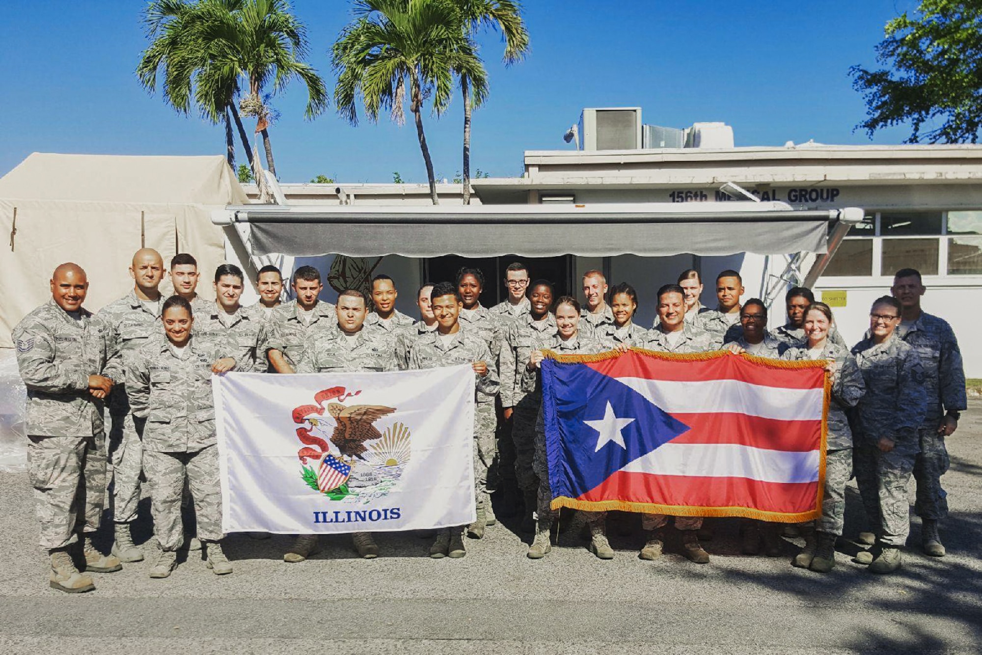 Illinois Air National Guard services specialists posing with Illinois and Puerto Rican flags.