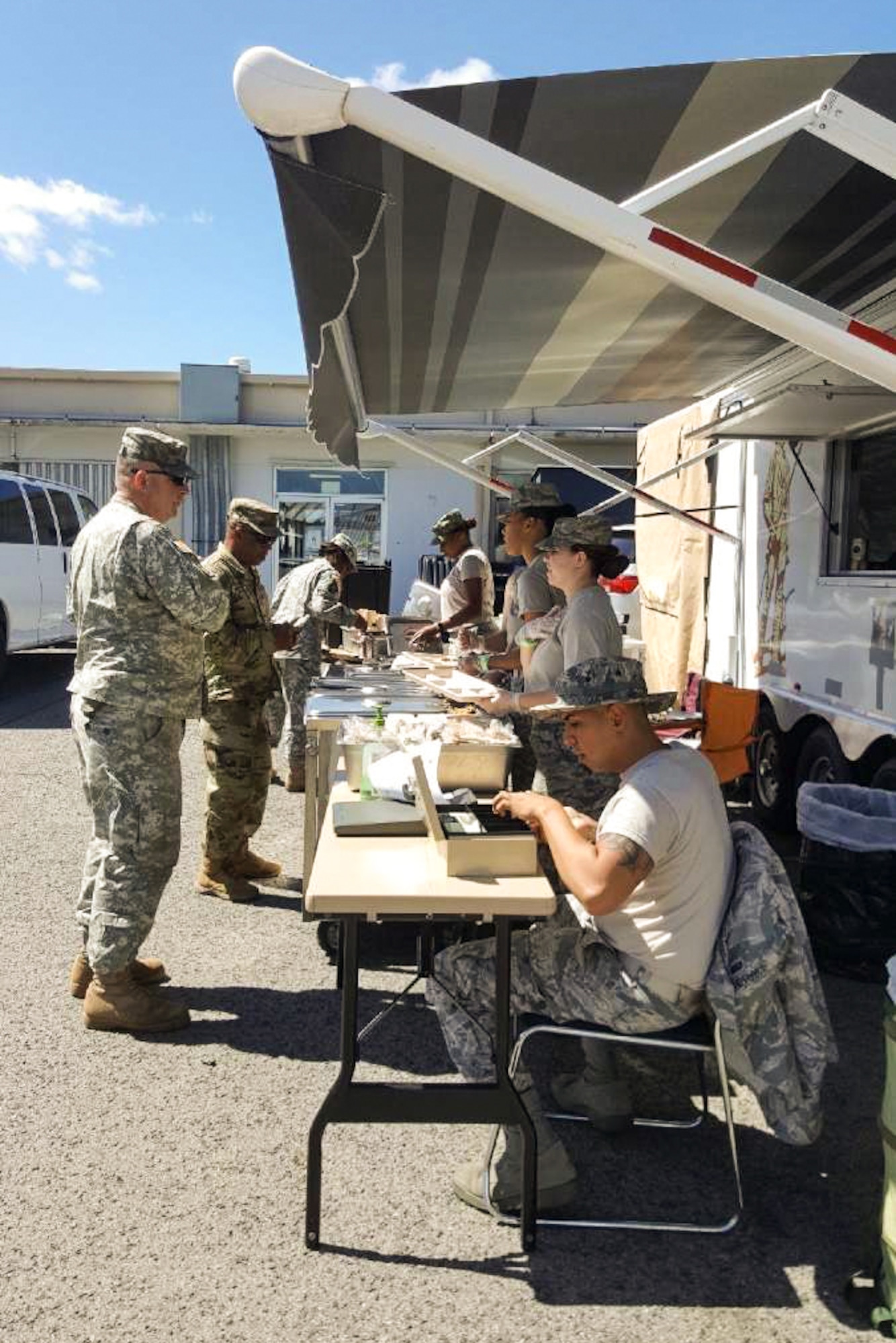 Illinois Air National Guard services specialists serving meals from a Disaster Relief Mobile Kitchen Trailer during a 2017 deployment to Puerto Rico.