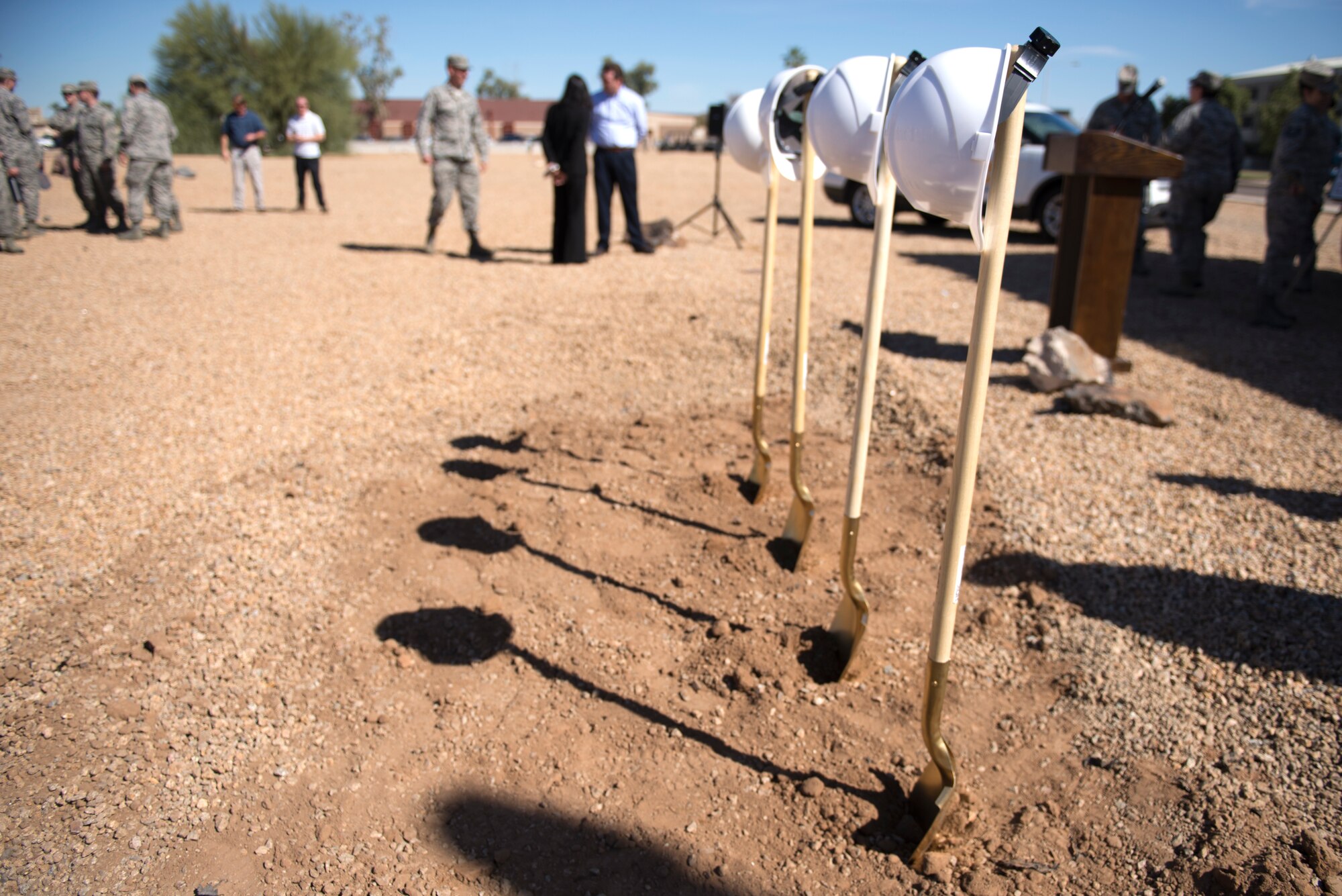 Construction helmets sit atop painted shovels before the start of the groundbreaking ceremony for the 56th Communications Squadron’s new facility at Luke Air Force Base, Ariz., March 28, 2018. The new facility will consolidate the 56th CS, currently split between three locations, into one location for the first time. (U.S. Air Force photo by Senior Airman Ridge Shan)