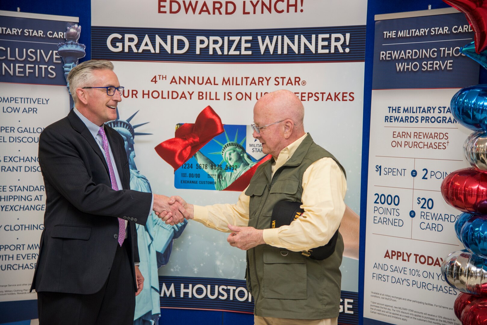 Retired Army Col. Edward Lynch (right) is congratulated by  James Jordan, Exchange chief financial officer, after receiving a $2,500 check to pay off his Military Star card balance at the Joint Base San Antonio-Fort Sam Houston Exchange April 4. Lynch was entered into the contest when he used his card last fall to make a purchase