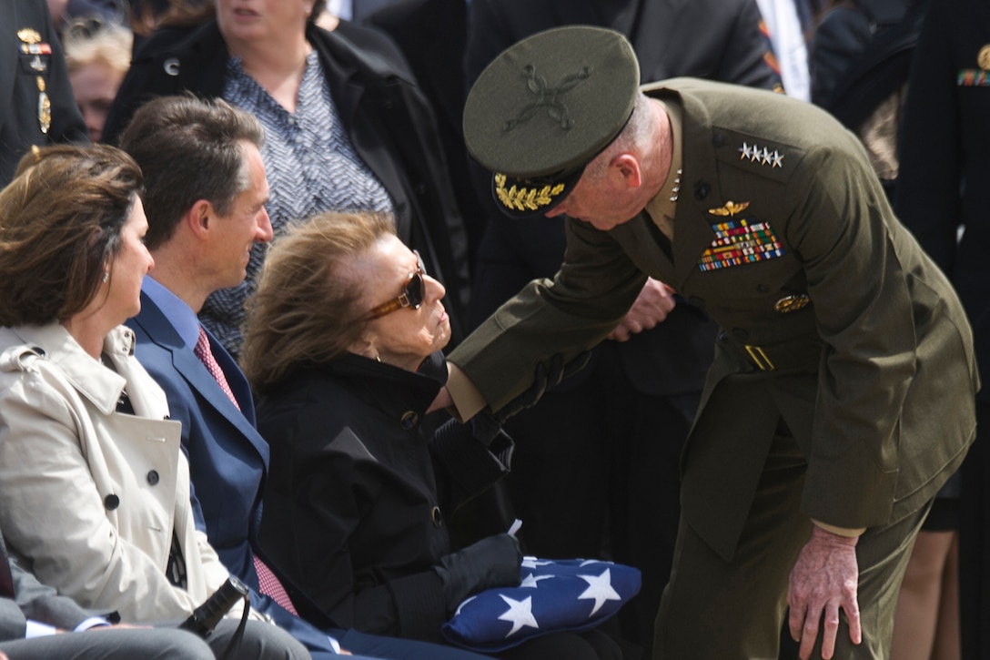Marine Corps Gen. Joe Dunford, chairman of the Joint Chiefs of Staff, consoles a civilian who is holding a folded flag.