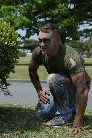 CAMP LESTER, OKINAWA, Japan – Lance Cpl. Kaiten DeArment crouches behind a bush dressed as a zombie during the American Red Cross hosted Zombie Run March 31 aboard Camp Lester, Okinawa, Japan.