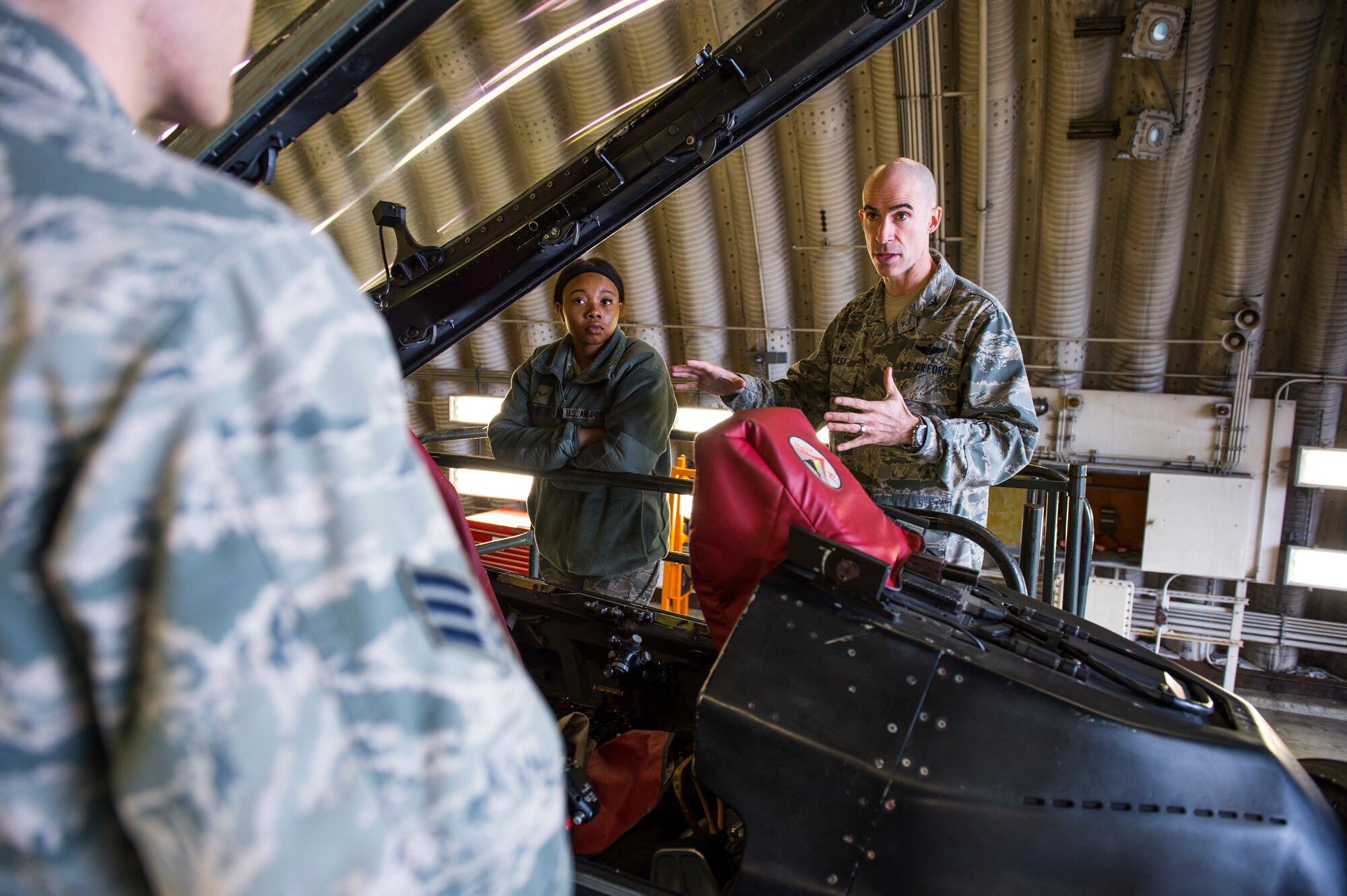 U.S. Air Force Col. Jason Bailey, 52nd Fighter Wing commander, educates Airman 1st Class Leah Crawford, 52nd Logistics Readiness Squadron fleet management analyst journeyman, and others about the different capabilities of an F-16 Fighting Falcon at Spangdahlem Air Base, Germany, April 4, 2018. Bailey explained the functions and capabilities of the aircraft as an opportunity to expand their knowledge of the flying mission at Spangdahlem. (U.S. Air Force photo by Senior Airman Dawn M. Weber)