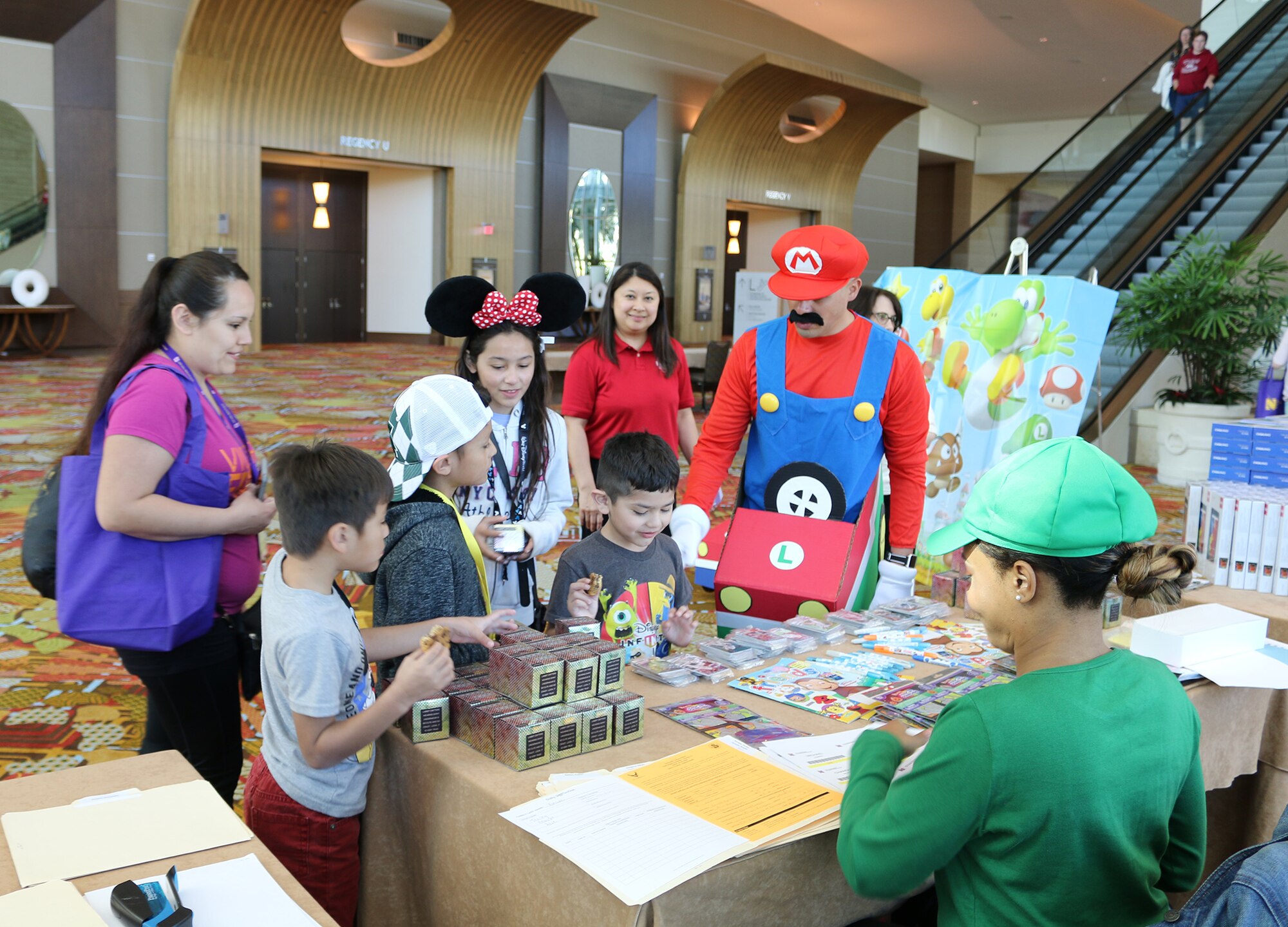 The family of Senior Airman Faustino Estrada, 445th Logistics Readiness Squadron, registers at a Mario themed table during the Yellow Ribbon Reintegration Program held in Orlando, Florida March 16, 2018