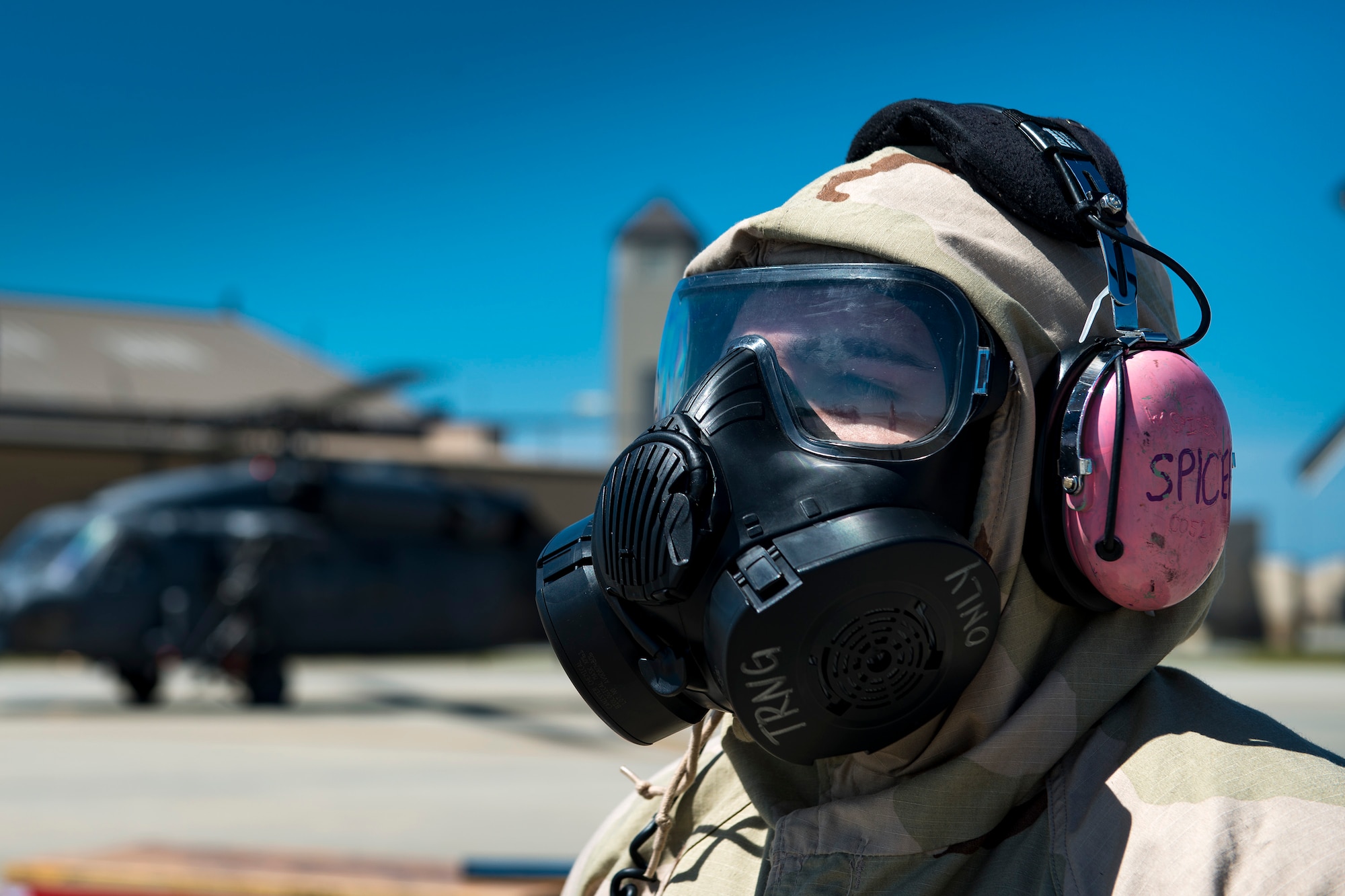 Senior Airman Wil Spicer, 41st Helicopter Maintenance Unit instrument and flight control technician, waits to marshal an HH-60G Pave Hawk during a chemical, biological, radiological and nuclear exercise, March 28, 2017, at Moody Air Force Base, Ga. The Airmen were geared up in mission-oriented protective posture (MOPP) gear to simulate potential conditions they could face while deployed in austere environments. While in MOPP gear, Airmen have to deal with claustrophobic conditions, impaired communication and battle the constant threat of heat exhaustion, while completing the mission. (U.S. Air Force photo by Airman 1st Class Erick Requadt)