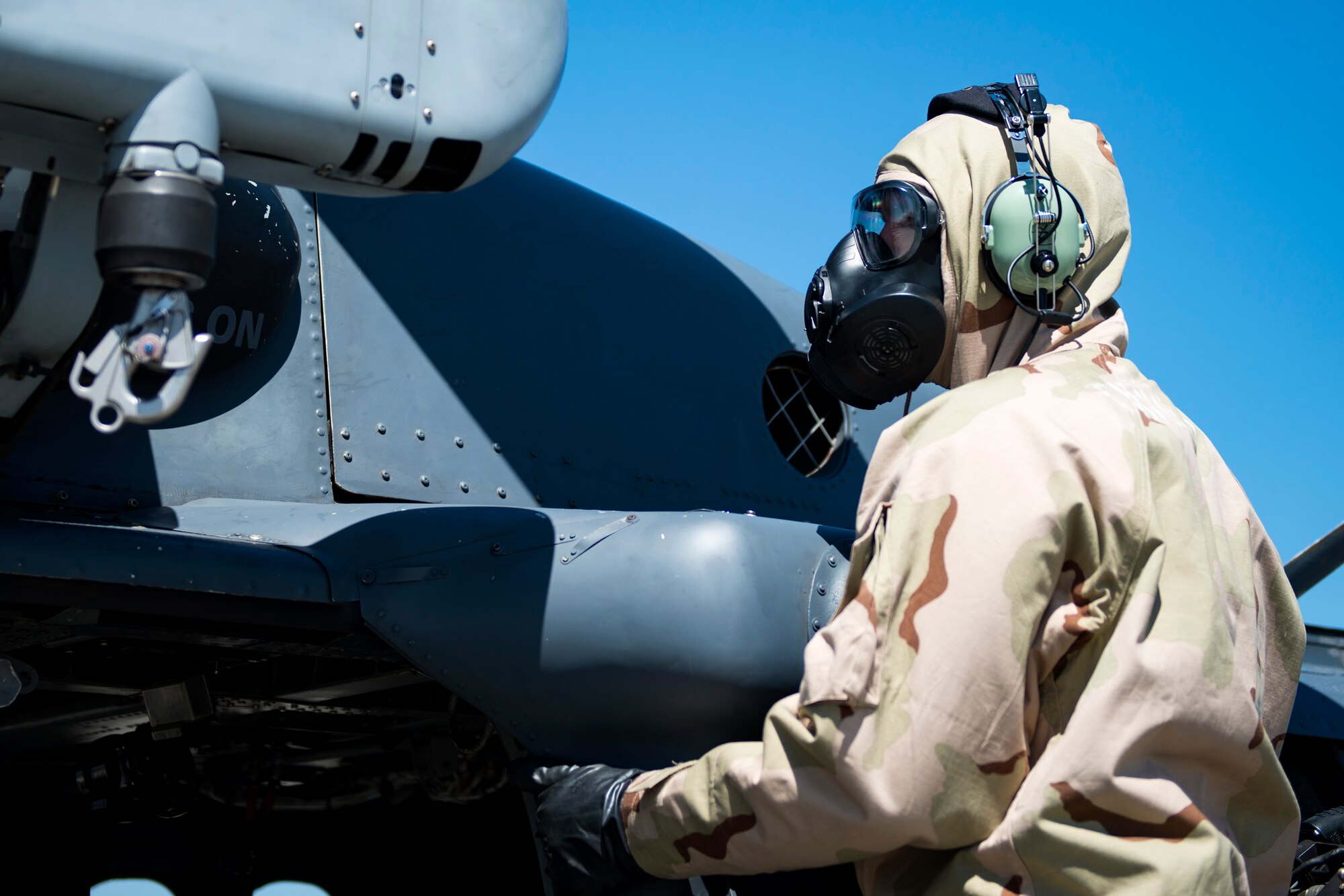 Senior Airman Zachary Oswald, 41st Helicopter Maintenance Unit crew chief, conducts a post-flight foreign object debris inspection on an HH-60G Pave Hawk during a chemical, biological, radiological and nuclear exercise, March 28, 2017, at Moody Air Force Base, Ga. The Airmen were geared up in mission-oriented protective posture (MOPP) gear to simulate potential conditions they could face while deployed in austere environments. While in MOPP gear, Airmen have to deal with claustrophobic conditions, impaired communication and battle the constant threat of heat exhaustion, while completing the mission. (U.S. Air Force photo by Airman 1st Class Erick Requadt)