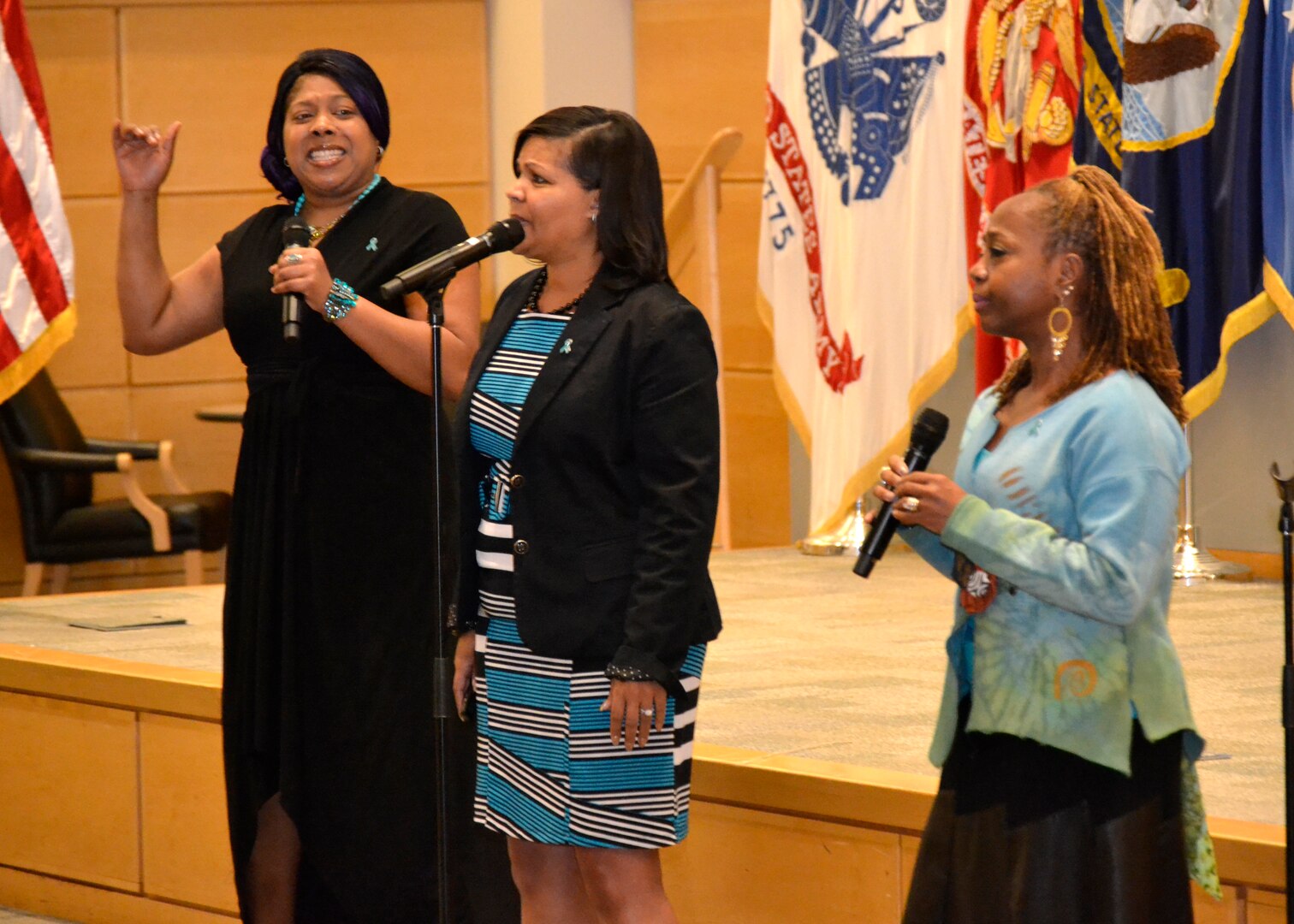 LaTosha Wray, Ella Wynn and Dawn Morgan-Moore sing a rendition of Andra Day's "Stand Up For Something" at DLA Troop Support's "Speak Up, Stand Up" empowerment event April 4 in Philadelphia.