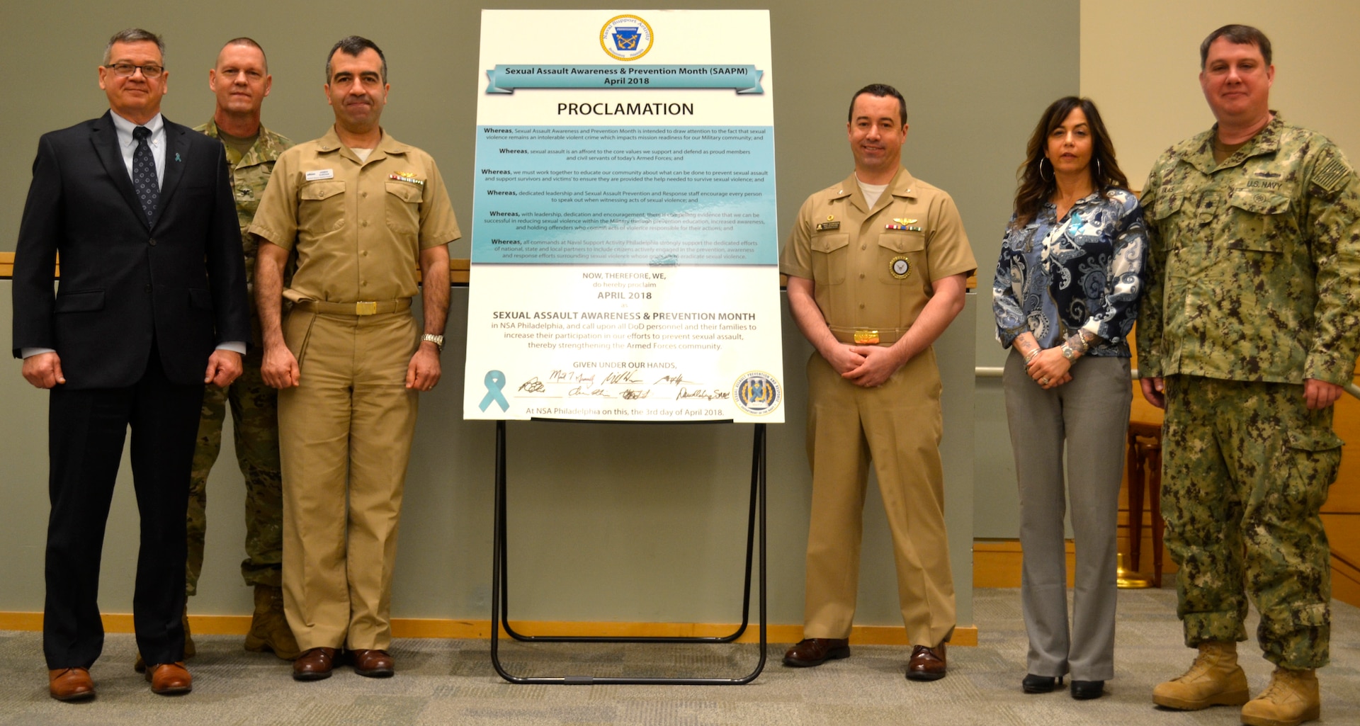 NSA Philadelphia tenant command representatives and Sexual Assault Prevention and Response program leads stand together after signing the 2018 Sexual Assault Awareness and Prevention Month proclamation at DLA Troop Support in Philadelphia April 3.