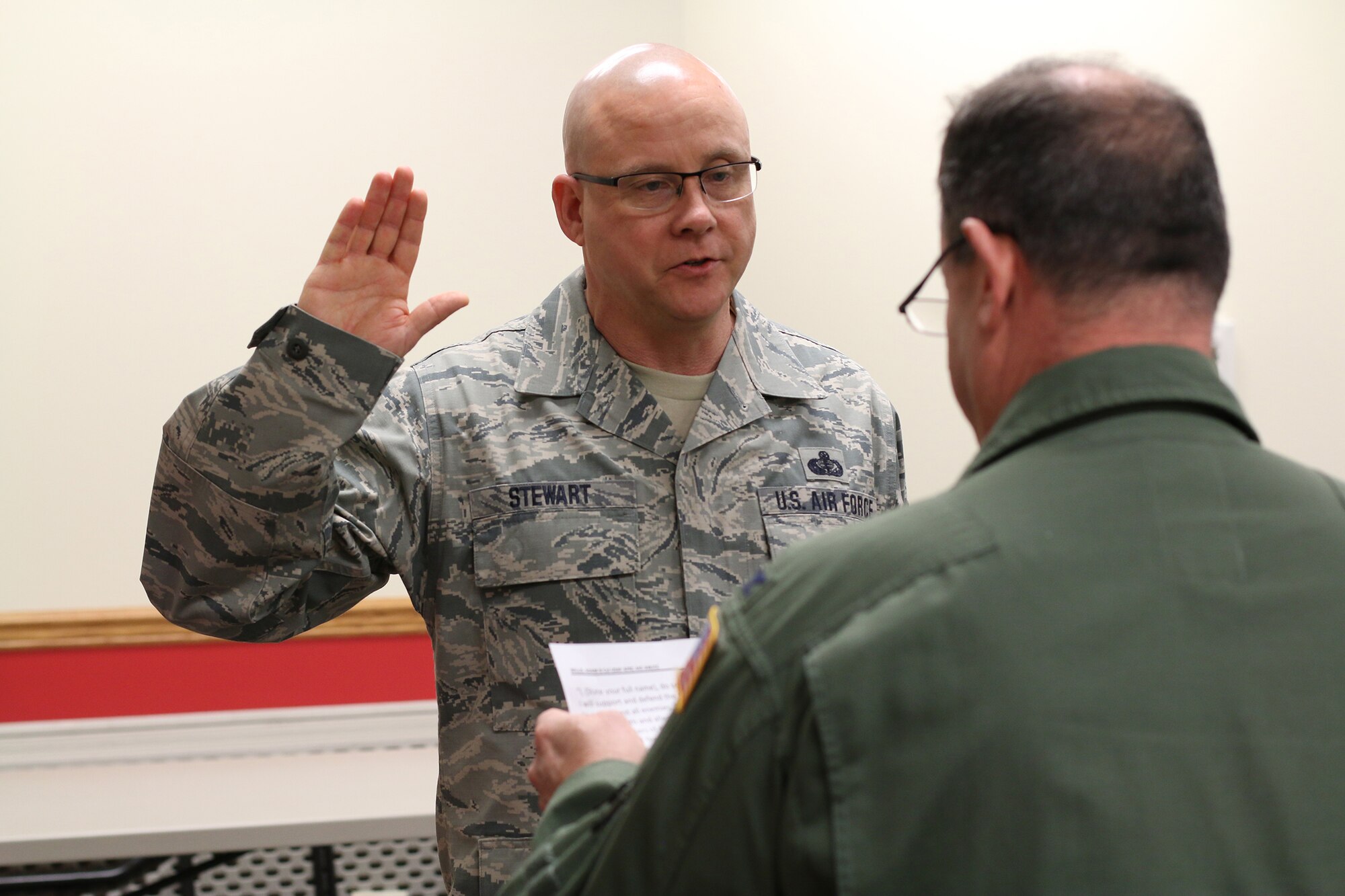 Col. Adam Willis, 445th Airlift Wing commander, administers the Oath of Enlistment to Chief Master Sgt. Paul Stewart, 445 AW command chief, March 3, 2018. This event marks Chief’s Stewart’s final enlistment.