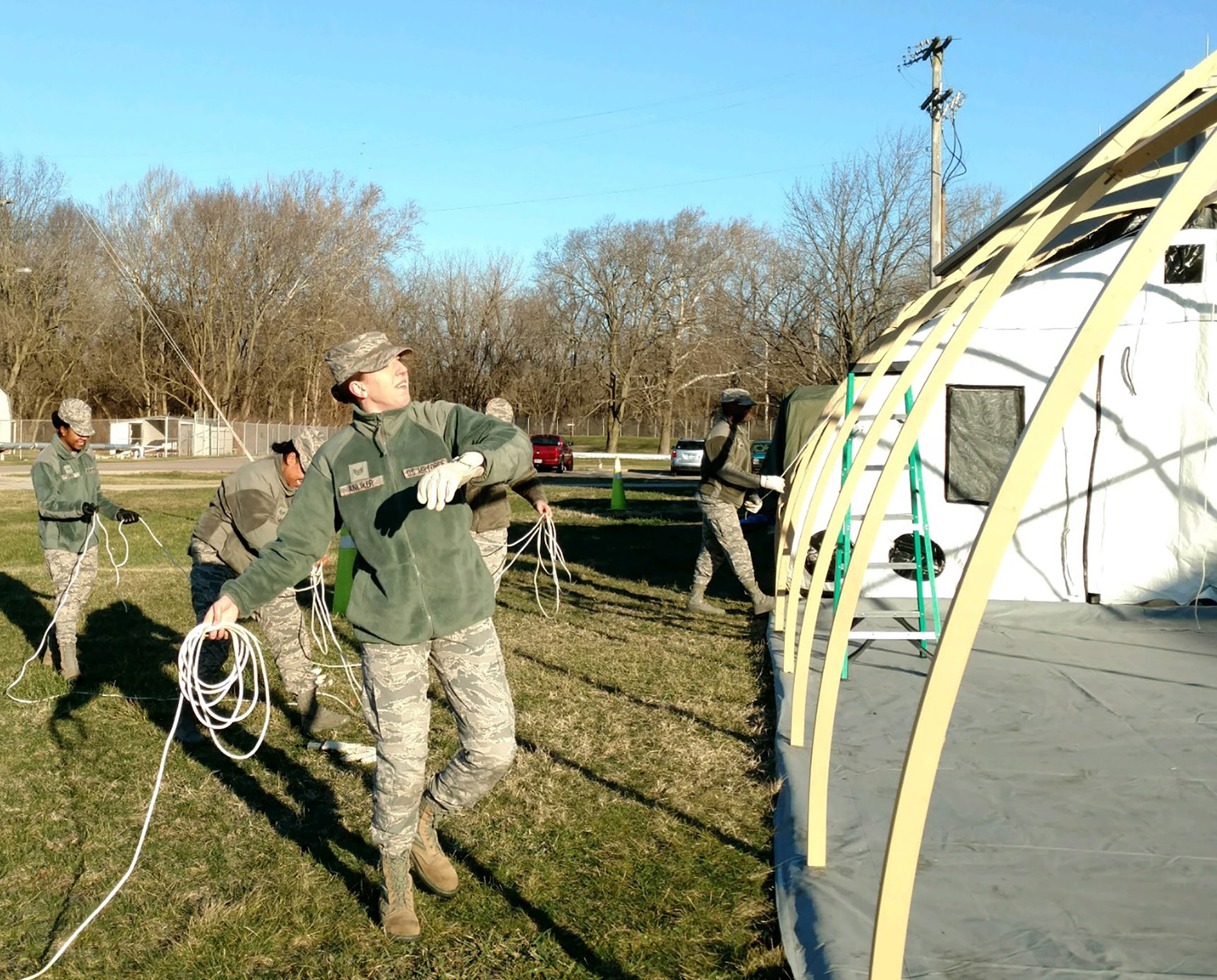 Staff Sgt. Taylor Anliker, 445th Force Support Squadron, tosses tent securing ropes as part of the assembly of a temporary lodging facility constructed during the March 4, 2018 unit training assembly at Wright-Patterson Air Force Base, Ohio.