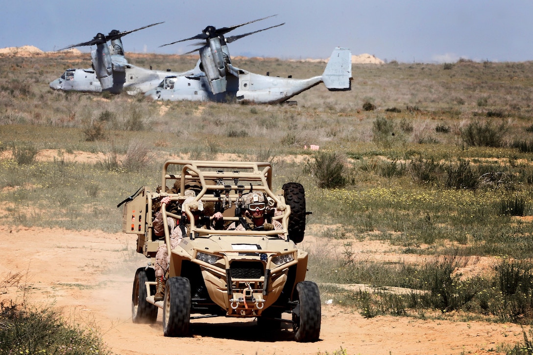 Marines drive an all-terrain vehicle.