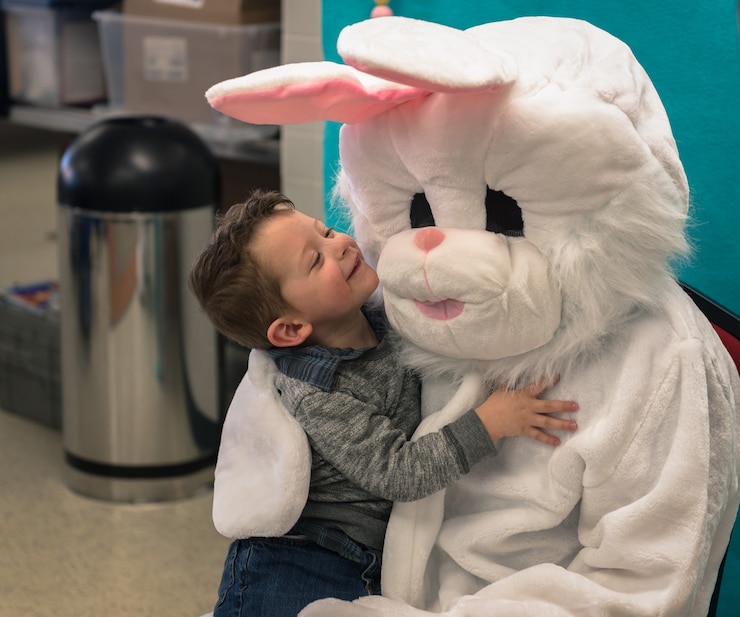 Child hugging and smiling at the Easter bunny.