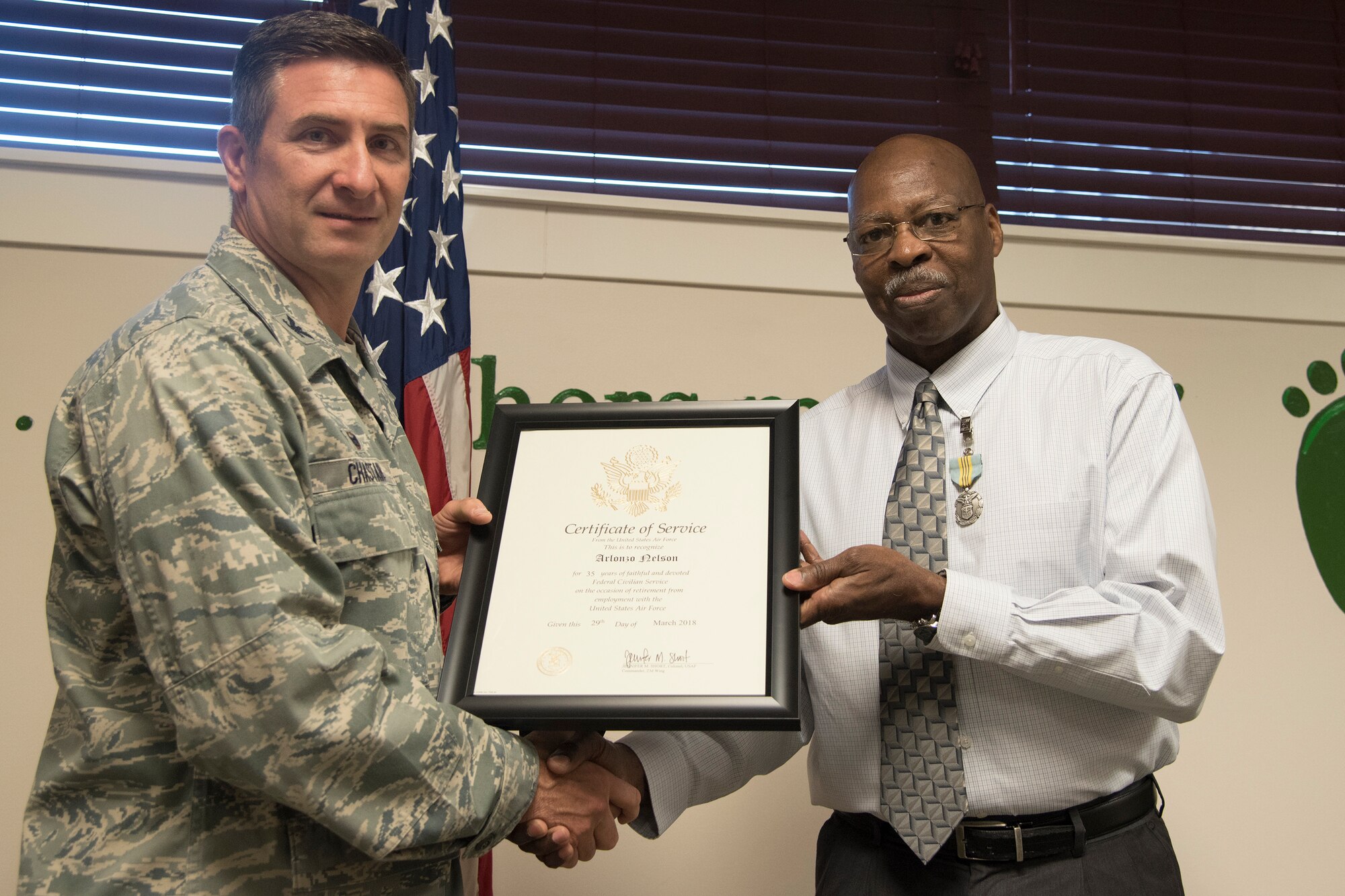 Col. John Chastain, left, 23d Maintenance Group (MXG) commander and Arlonzo Nelson, 23d MXG computer assistant, pose for a photo, during a retirement ceremony March 29, 2018, at Moody Air Force Base, Ga. Nelson is retiring after 30 years of civilian service here. (U.S. Air Force photo by Airman Eugene Oliver)