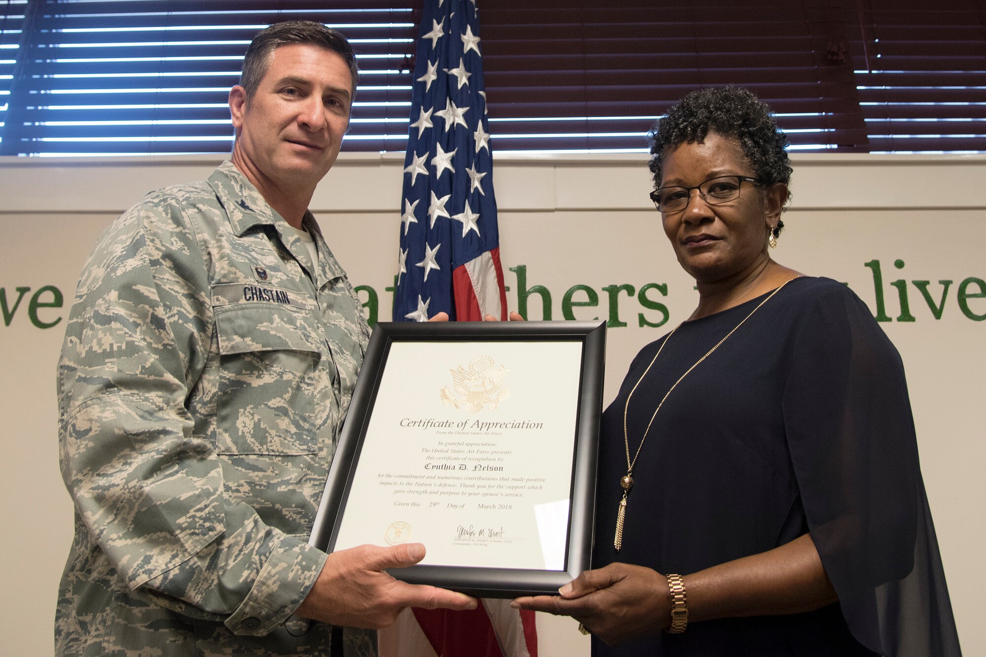 Col. John Chastain, left, 23d Maintenance Group (MXG) commander, and Cynthia Nelson, spouse of Arlonzo Nelson, 23d Maintenance Group computer assistant pose for a photo, during a retirement ceremony, March 29, 2018, at Moody Air Force Base, Ga. Nelson is retiring after 30 years of civilian service here. (U.S. Air Force photo by Airman Eugene Oliver)