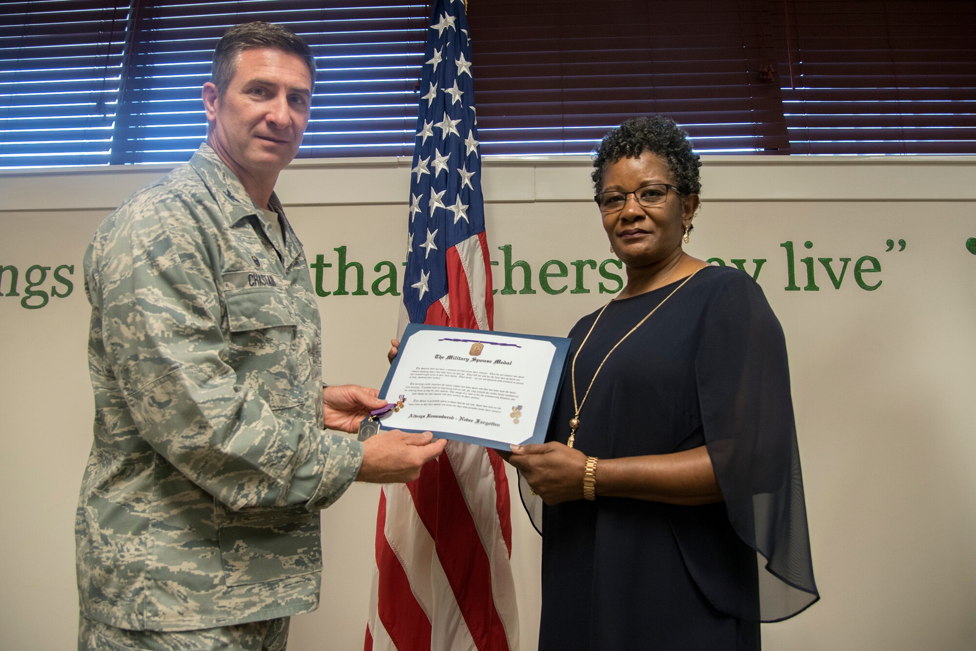 Col. John Chastain, left, 23d Maintenance Group (MXG) commander, and Cynthia Nelson, spouse of Arlonzo Nelson, 23d Maintenance Group computer assistant, pose for a photo, during a retirement ceremony, March 29, 2018, at Moody Air Force Base, Ga. Nelson is retiring after 30 years of civilian service here. (U.S. Air Force photo by Airman Eugene Oliver)