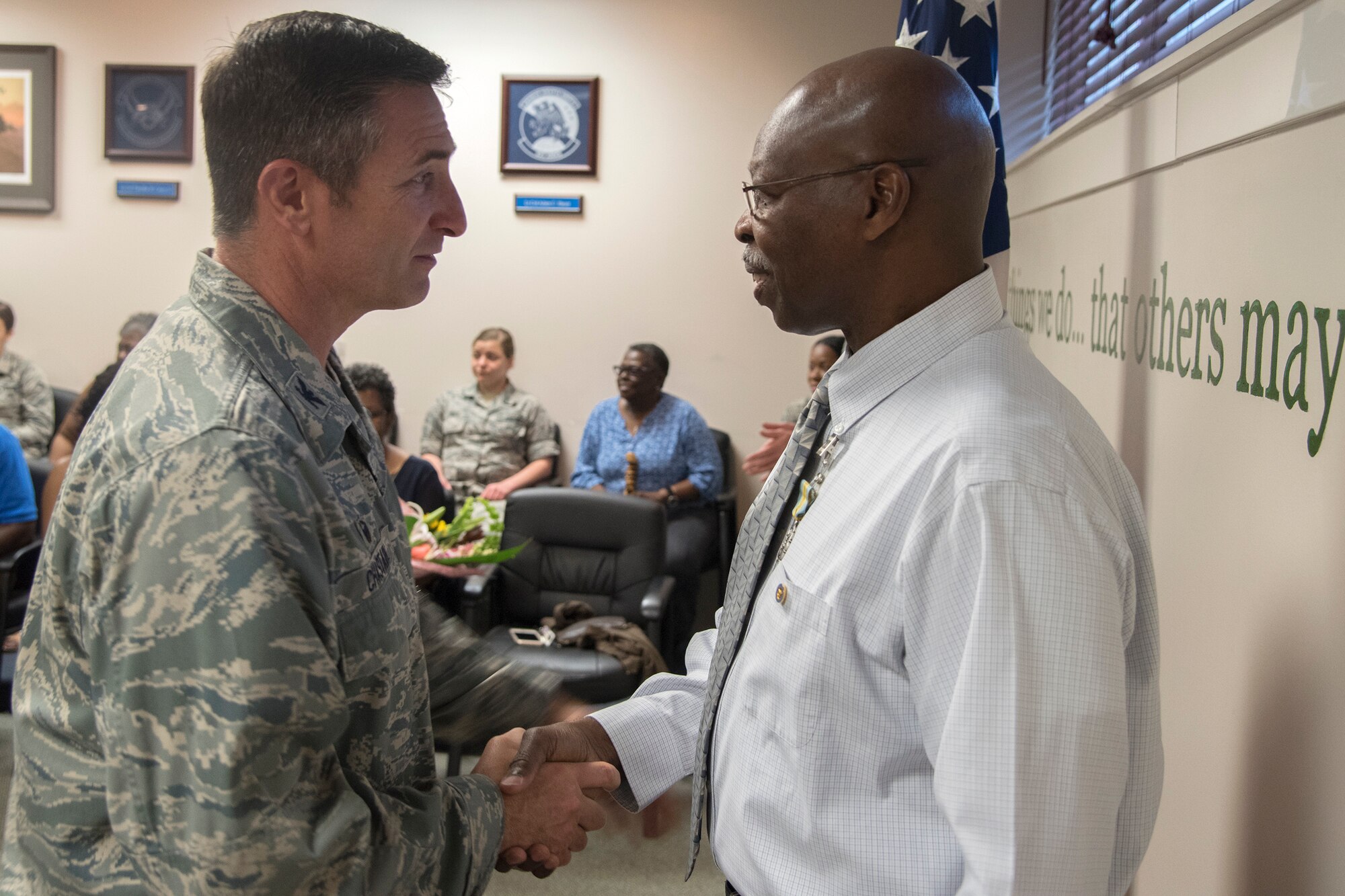 Col. John Chastain, left, 23d Maintenance Group (MXG) commander, shakes hands with Arlonzo Nelson, 23d MXG computer assistant during a retirement ceremony, March 29, 2018, at Moody Air Force Base, Ga. Nelson is retiring after 30 years of civilian service here. (U.S. Air Force photo by Airman Eugene Oliver)