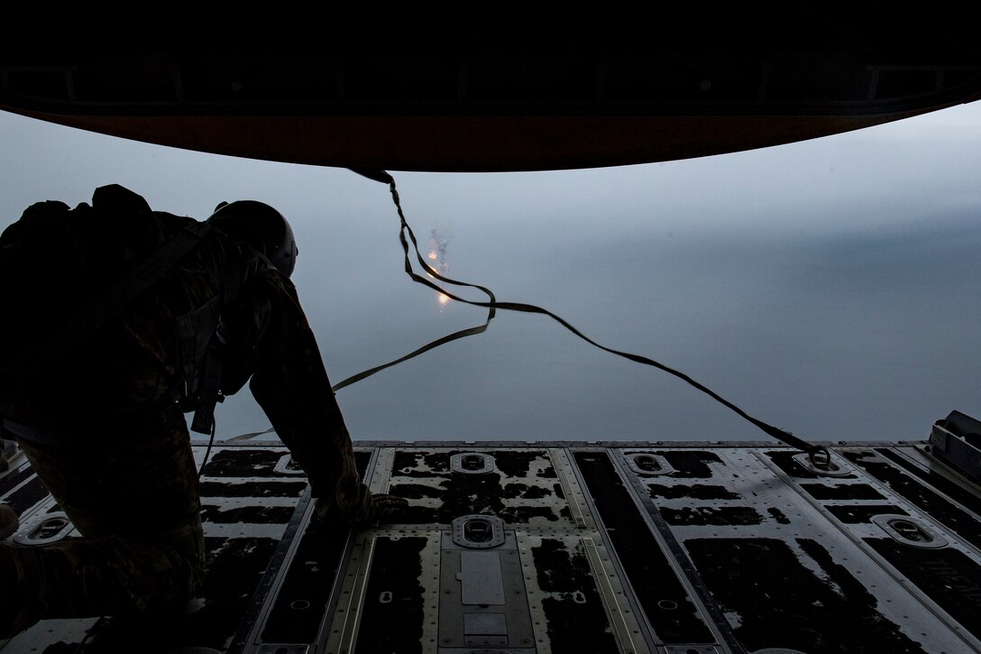 Staff Sgt. James Baker, 71st Rescue Squadron loadmaster, watches as flares burn behind the aircraft during pyrotechnic employment training, March 30, 2018, in the skies over the Gulf of Mexico. The 71st RQS utilizes various pyrotechnics and sea-dye to assist in over-water rescue efforts. (U.S. Air Force photo by Staff Sgt. Ryan Callaghan)