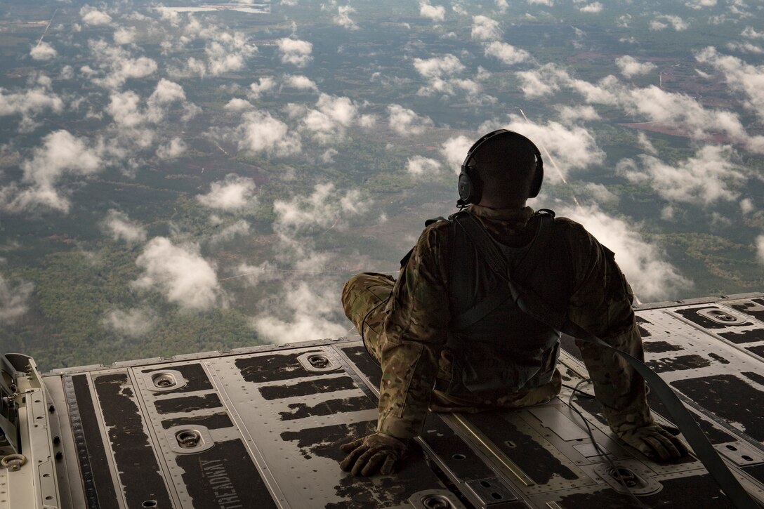 Staff Sgt. James Baker, 71st Rescue Squadron loadmaster, sits on the ramp in the rear of an HC-130J Combat King II, March 30, 2018, in the skies over Florida. As a loadmaster, Baker is responsible for calculating aircraft weight and balance records, maintaining the cargo manifest, conducting cargo and personnel airdrops, and troubleshooting in-flight problems. (U.S. Air Force photo by Staff Sgt. Ryan Callaghan)