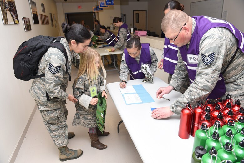 Military children process through a deployment line during Kids Understanding Deployment Operations, April 4, 2018, Vandenberg Air Force Base, Calif. KUDOS is a program developed to give children a deeper understanding of the military deployment process and equipment utilized during a deployment. (U.S. Air Force photo by Tech. Sgt. Jim Araos/Released)