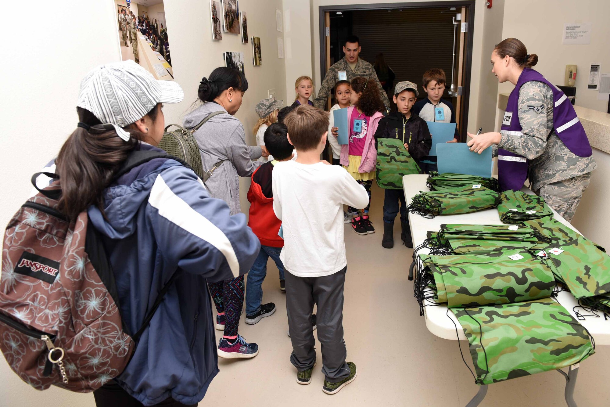 Military children process through a deployment line during Kids Understanding Deployment Operations, April 4, 2018, Vandenberg Air Force Base, Calif. KUDOS is a program developed to give children a deeper understanding of the military deployment process and equipment utilized during a deployment. (U.S. Air Force photo by Tech. Sgt. Jim Araos/Released)
